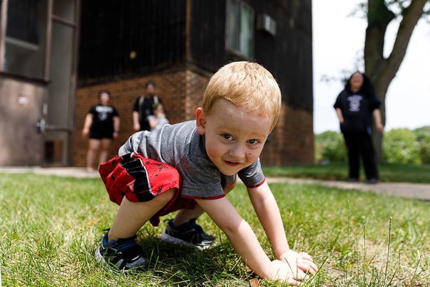 Joey Moore, 2, knows nothing about the fear his parents face as they cope with an unexpected, massive rent increase on their delapidated apartment building in Fairmont. His mother, Haley Beyer, left rear, takes a smoke break with neighbors Brandon and Crystal White after brainstorming ways to resist the increase.