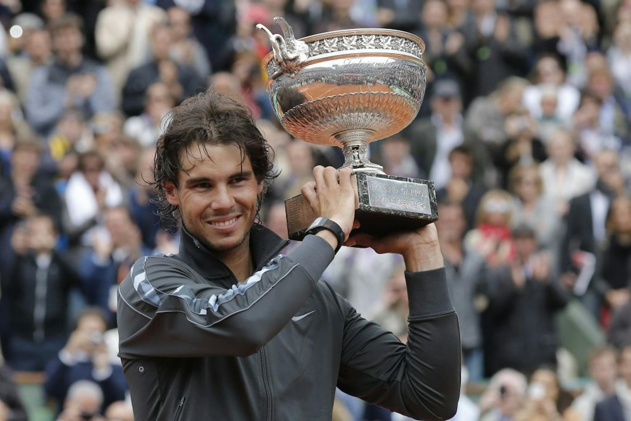 Rafael Nadal of Spain holds the trophy after winning the mens final match against Novak Djokovic of Serbia at the French Open tennis tournament in Roland Garros stadium in Paris, Monday June 11, 2012. Rain suspended the final making it the first French Open not to end on Sunday since 1973. Nadal clinched his seventh title in four sets 6-4, 6-3, 2-6, 7-5, passing Sweden's Bjorn Borg as the all-time record-holder for French Open titles.