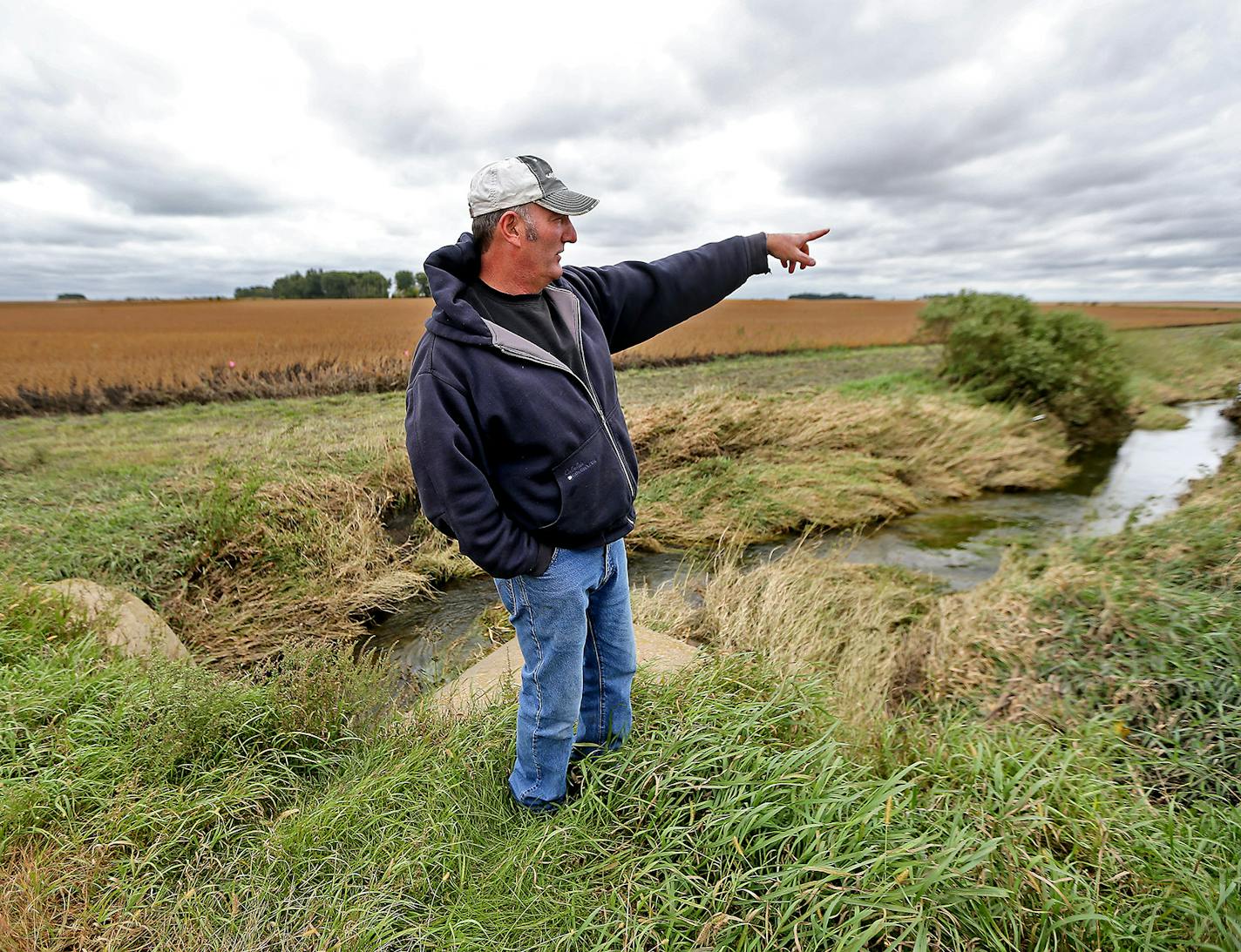 Joe Merten watched as county technicians staked out ground along Orchard Creek that runs through his property, where he will plant grasses.