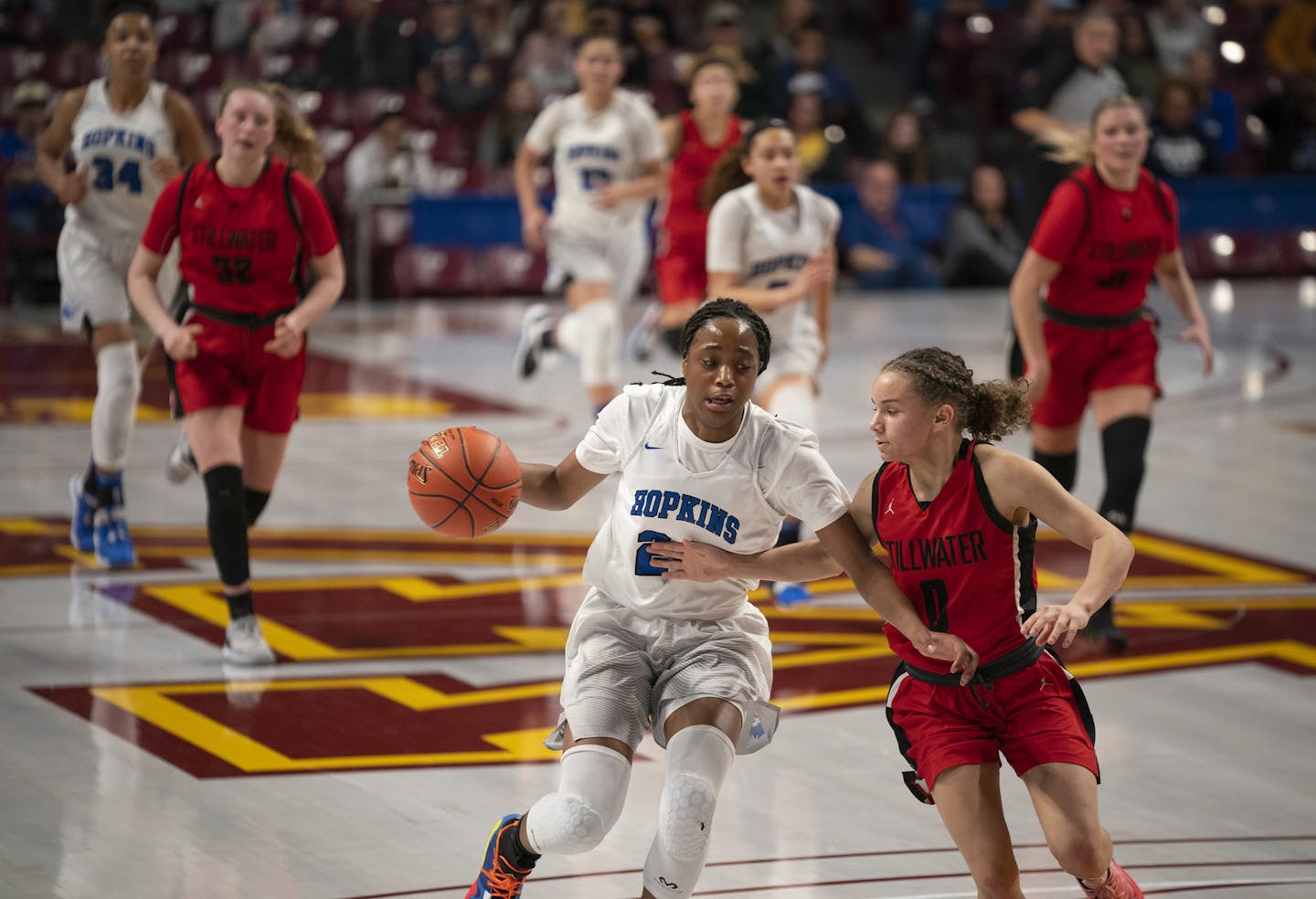 Hopkins guard Sunaja Agara (24) was defended on a fast break by Stillwater guard Alex Pratt (0) during the Class 4A state tournament semifinals on March 12, the last day of basketball before the COVID-19 pandemic shut down high school sports.