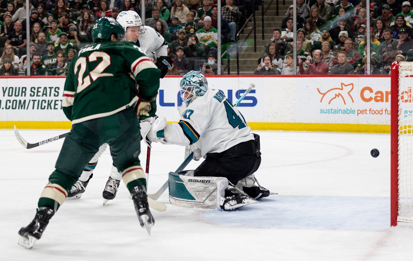 Kevin Fiala of the Wild gets the puck past San Jose Sharks goalie James Reimer in the third period Sunday