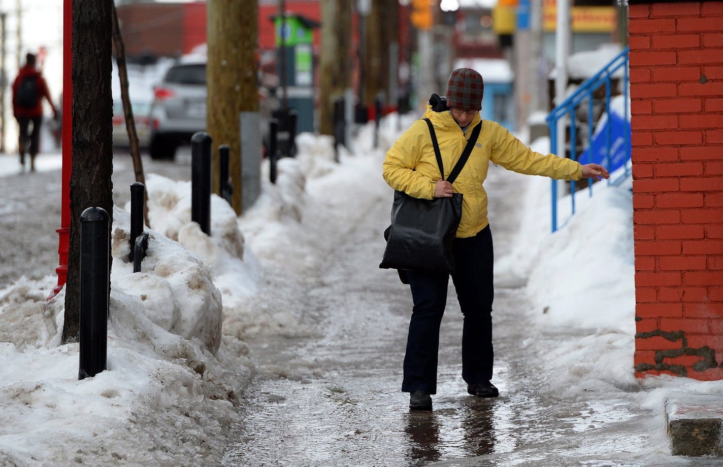 A pedestrian tries to navigates an ice covered sidewalk in Ottawa, Ontario, on Monday, Jan. 6, 2014. Temperatures are expected to drop 20 degrees by Monday night. Freezing Rain, Winter Storm and Wind Chill warnings have been issued for the region. (AP Photo/The Canadian Press, Sean Kilpatrick)