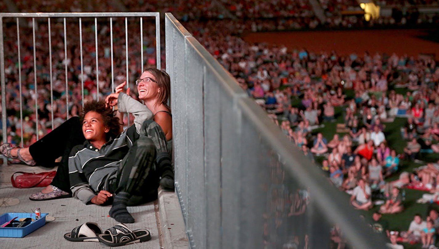 Michelle Poeschel and son Sai, 12, of Minneapolis lounge and laugh during the Cat Video Festival hosted by the Walker Arts Center. ] (KYNDELL HARKNESS/STAR TRIBUNE) kyndell.harkness@startribune.com Cat video festival at CHS Field in St Pauls, Min., Wednesday August 12, 2015. ORG XMIT: MIN1508122144440163