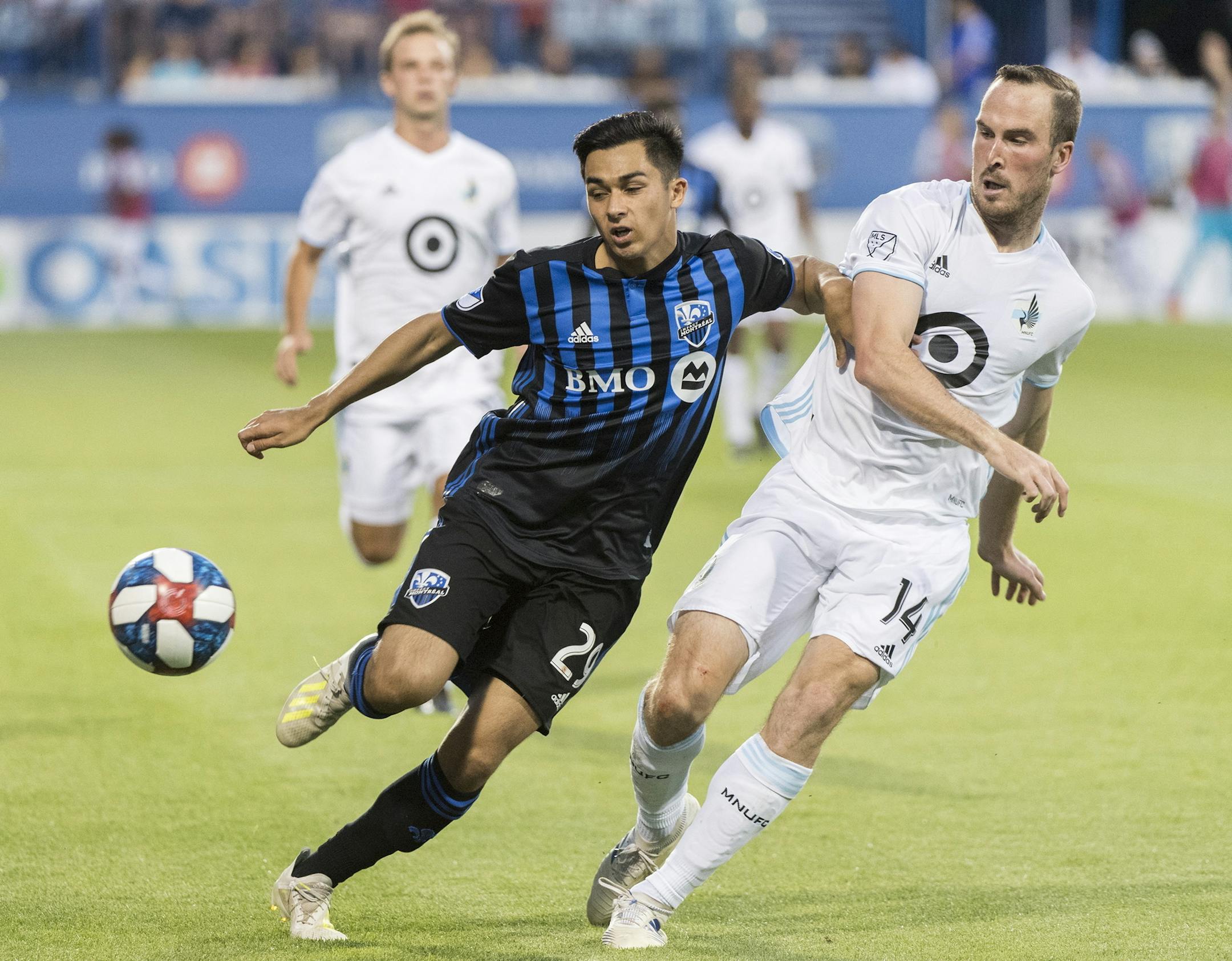 Montreal Impact's Mathieu Choiniere, left, tries to fend off Minnesota United's Brent Kallman during the second half of an MLS soccer match Saturday, July 6, 2019, in Montreal. (Graham Hughes/The Canadian Press via AP)