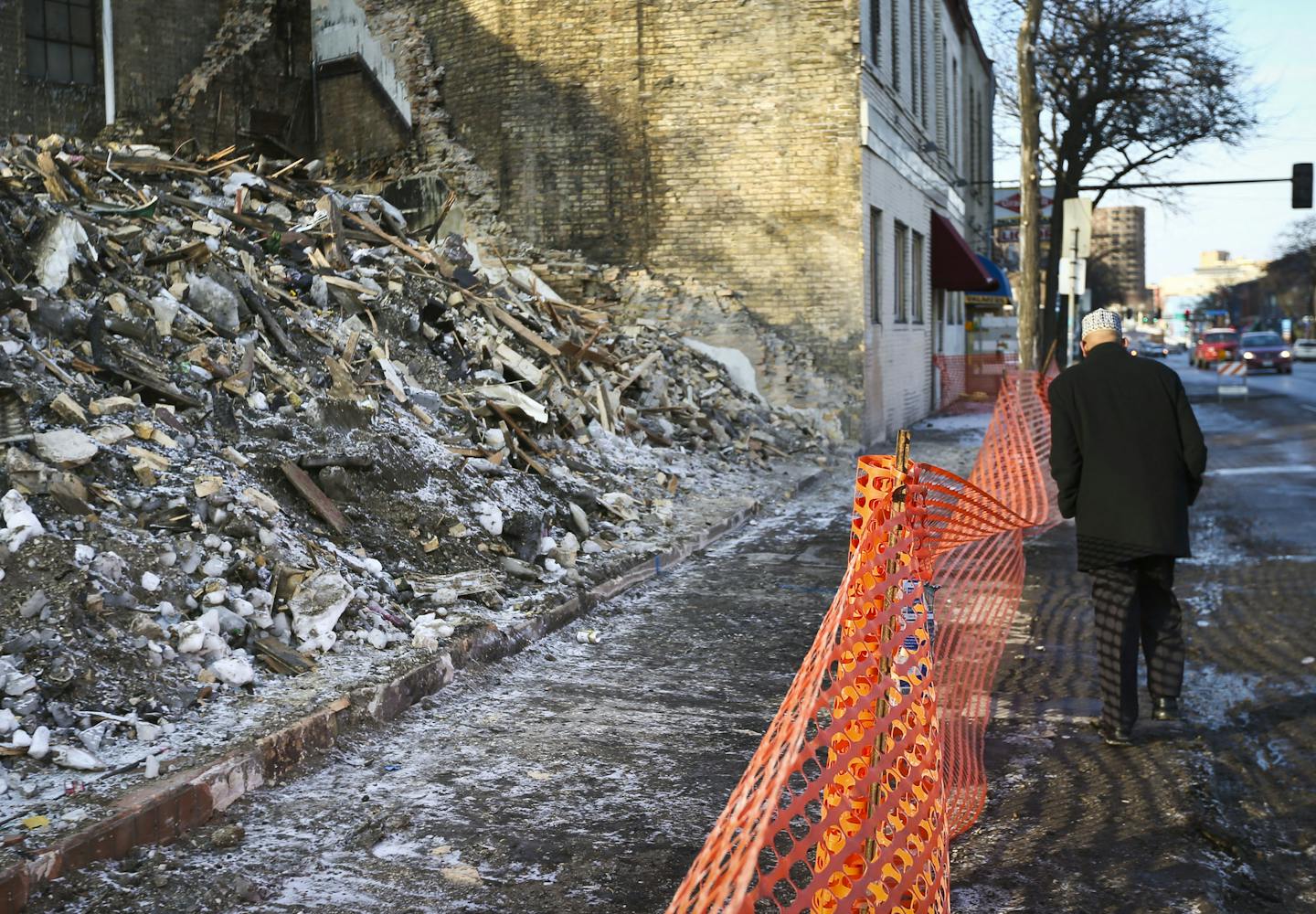 Imam Sharif Mohamed walked past the rubble of the apartment fire that killed three men and that damaged his mosque Dar Al-Hijrah next door. Photograph taken on Thursday, January 9, 2014, in Minneapolis, Minn. ] RENEE JONES SCHNEIDER &#x2022; reneejones@startribune.com