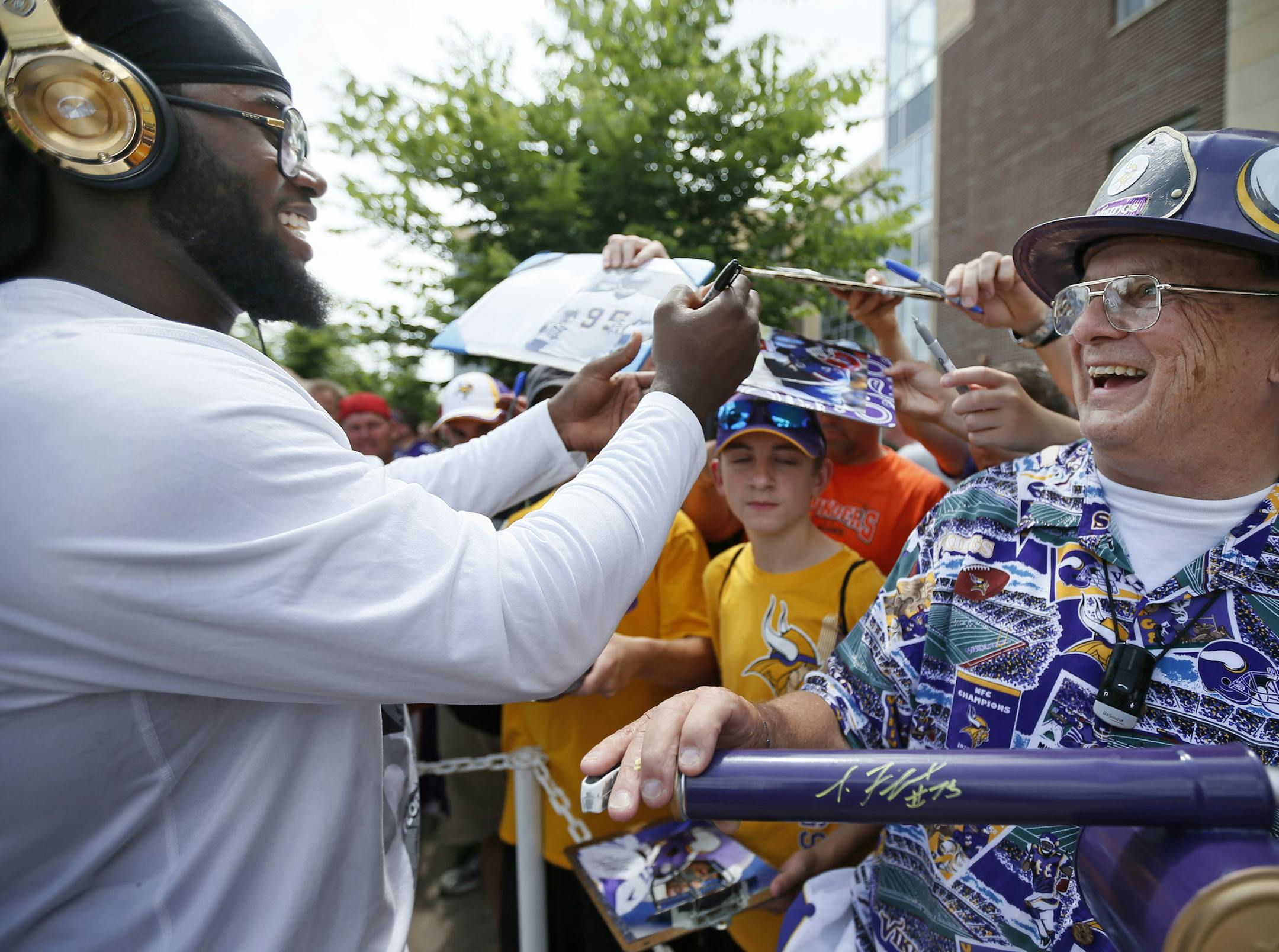 Milt Toratti, 71, of St. Peter (right) shared a laugh with defensive tackle Sharrif Floyd along the autograph line before the sweaty work of preparing for another NFL season gets underway.