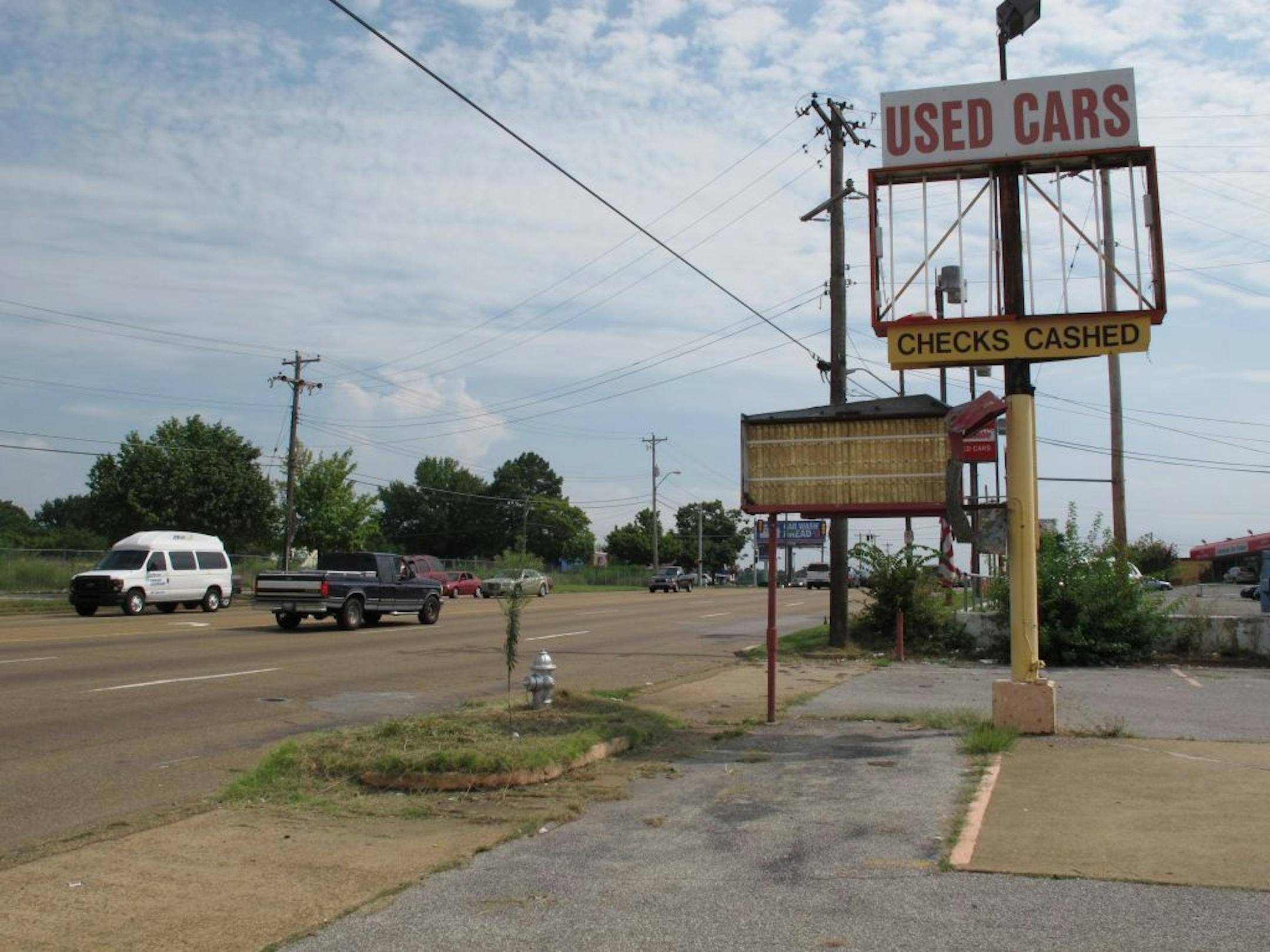 A dilapidated sign in front of a former used car dealership sits along Elvis Presley Blvd. on Tuesday, Aug. 6, 2013 in Memphis, Tenn.