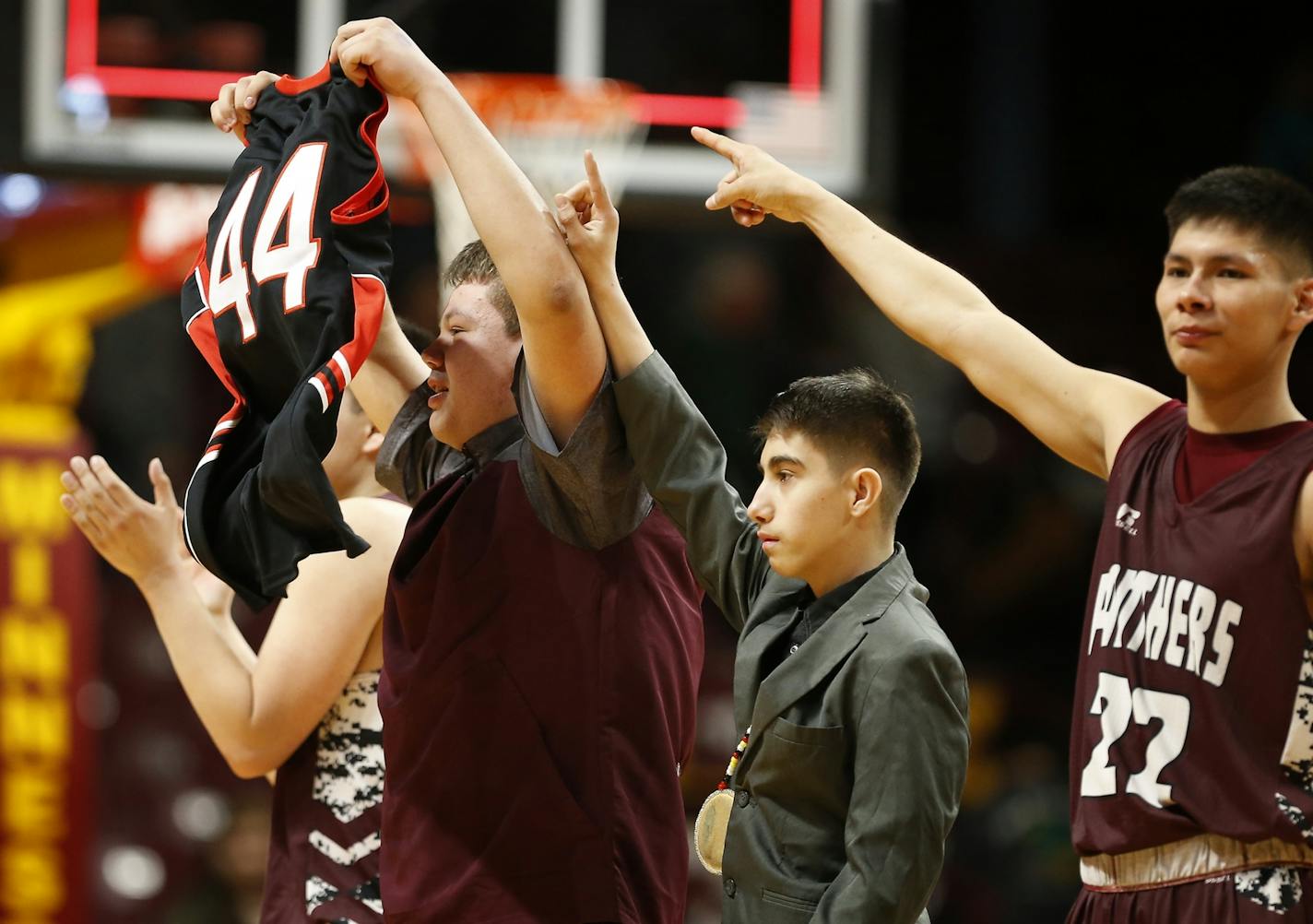 Cass Lake-Bena High School players hold up the #44 jersey of their missing teammate Jeremy Jourdain after winning over Rushford-Peterson High School in double overtime on Thursday.