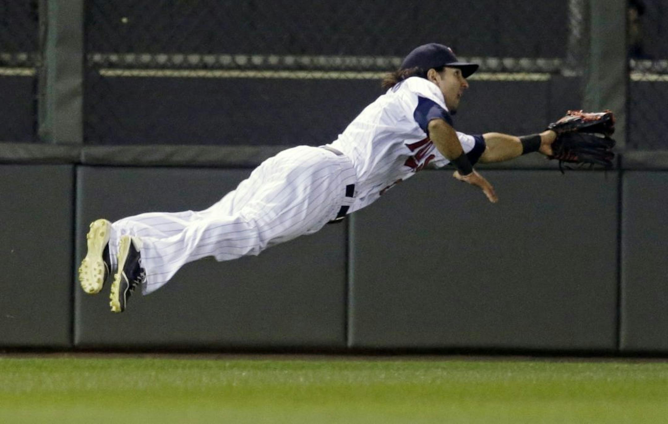 Minnesota Twins' left fielder Darin Mastroianni makes a futile dive on a double by Cleveland Indians' Nick Swisher in the first inning of a baseball game on Friday, Sept. 27, 2013, in Minneapolis.