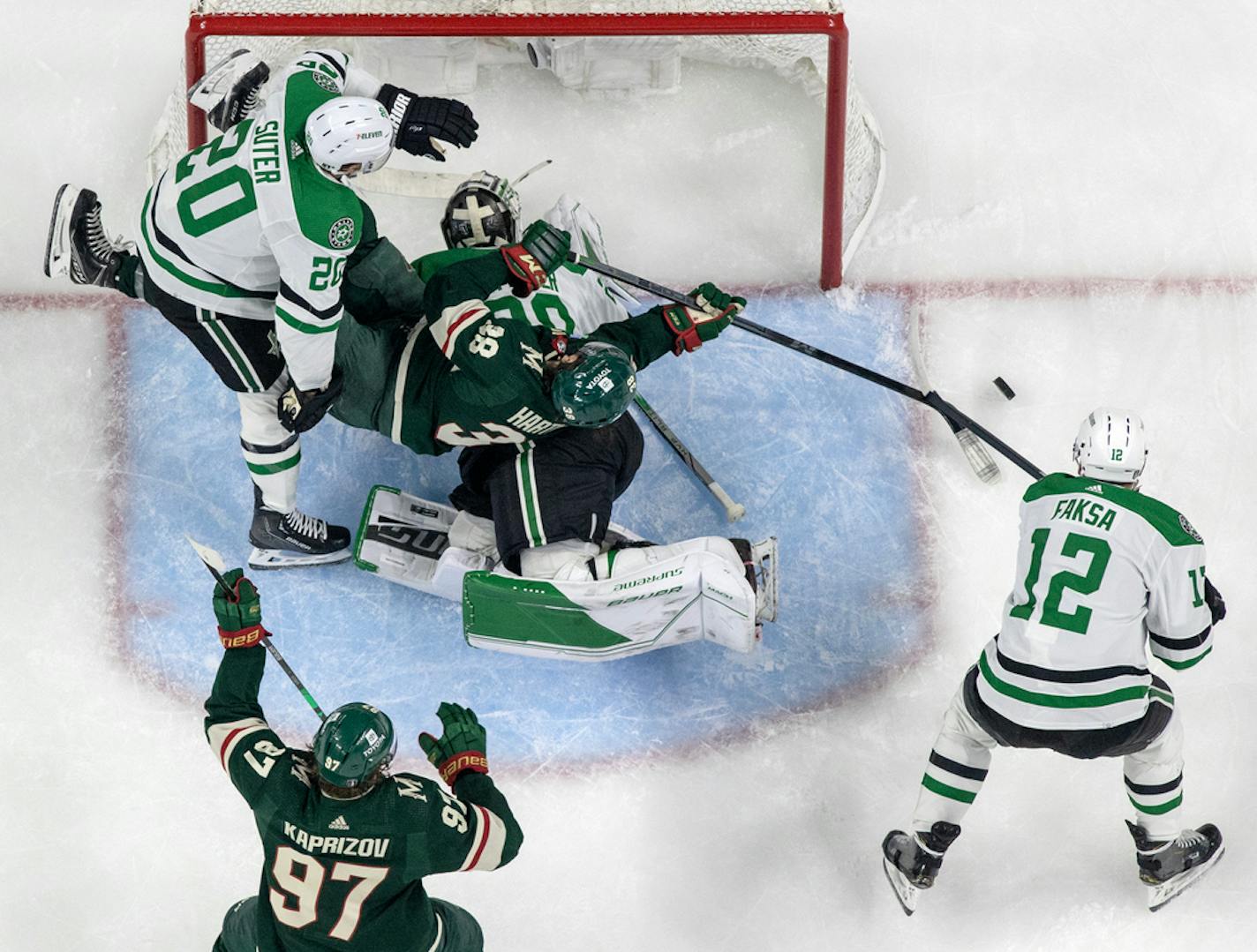 Ryan Suter (20) of the Dallas Stars tangled up with Ryan Hartman (38) of the Minnesota Wild near Dallas Stars goalie Jake Oettinger in the first period during Round 1, Game 6 of the NHL playoffs Friday, April 28, 2023, at Xcel Energy Center in St. Paul, Minn.   ] CARLOS GONZALEZ • carlos.gonzalez@startribune.com.