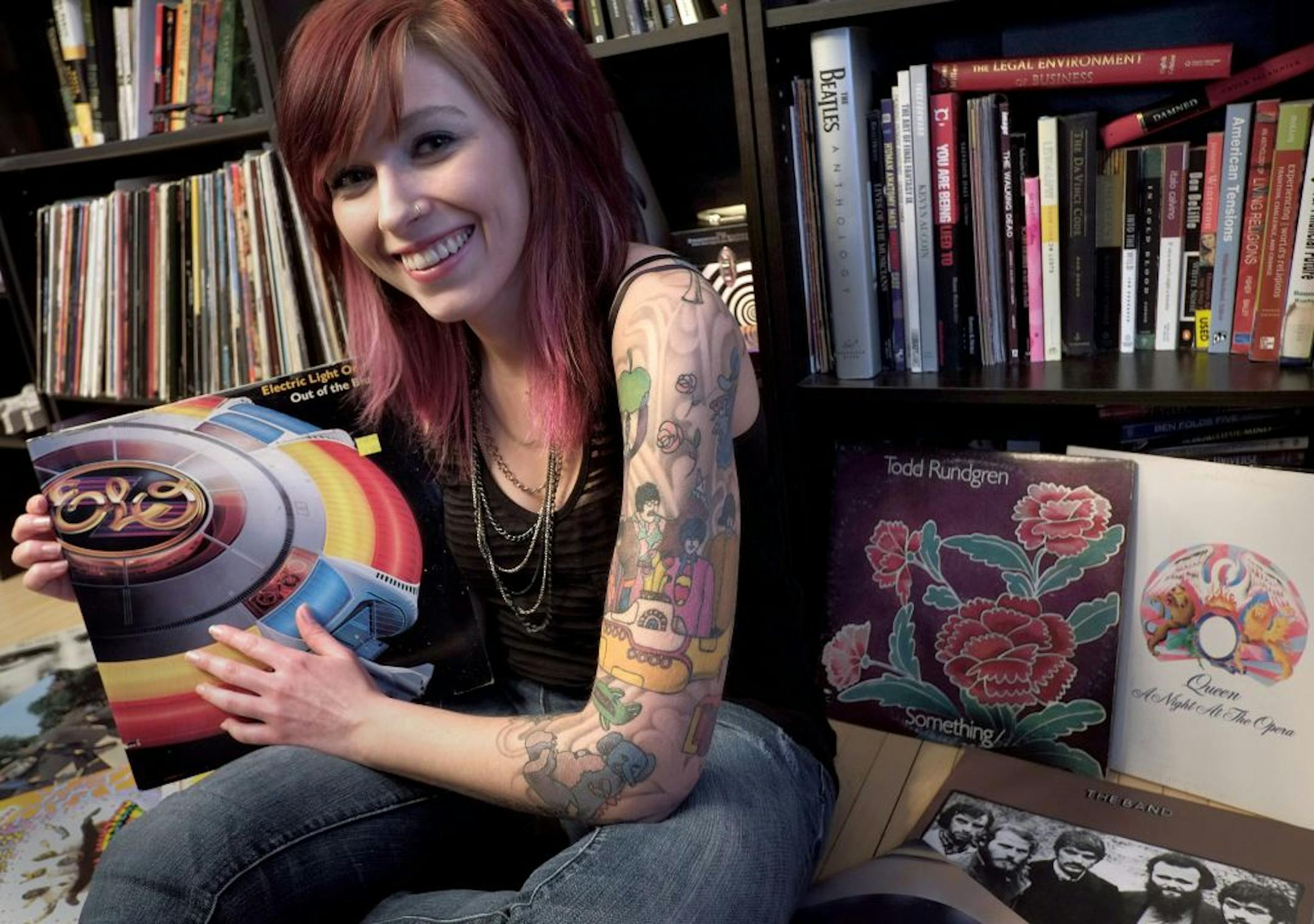 Stacey Combs shows off some of her collection of vintage vinyl at her North Minneapolis apartment. She wears her loyalty to the Beatles on her sleeve - a tattoo of the "Yellow Submarine" album cover artwork.