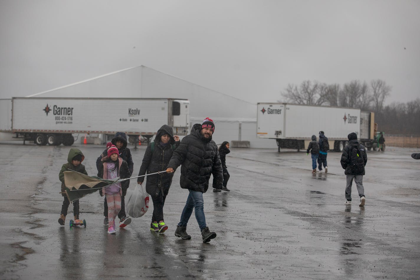 A migrant family from Venezuela left the tent complex used as shelter at Floyd Bennett Field in Brooklyn, on Jan. 9, 2024. New York City evacuated on Tuesday about 500 families with children — nearly 2,000 people in total — from a massive tent shelter set up on a desolate former airplane runway in southern Brooklyn ahead of heavy rains and wind expected to hit the area. (Kirsten Luce/The New York Times)