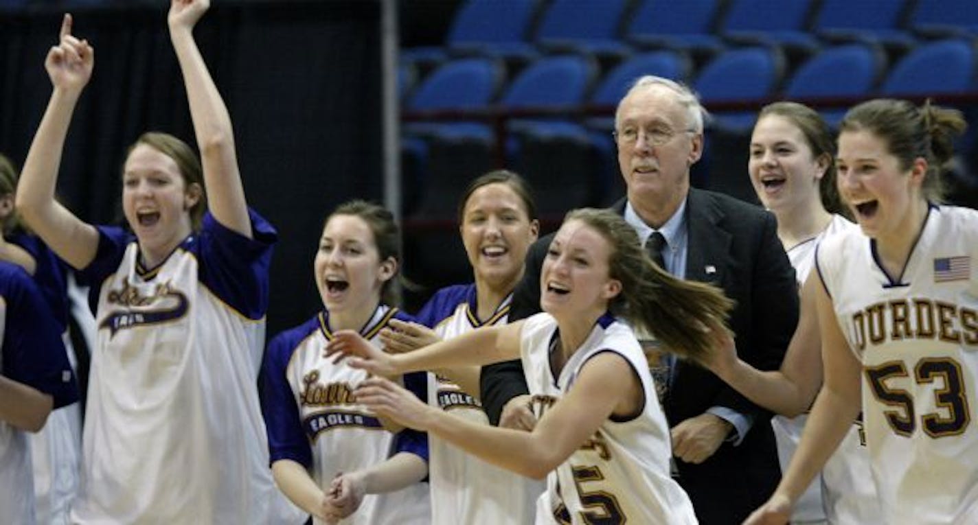 Rochester Lourdes' head coach Myron Glass is surrounded by members of the team as they rush the court after their 50-33 victory over Pequot Lakes in the Class 2A championship game in 2010.