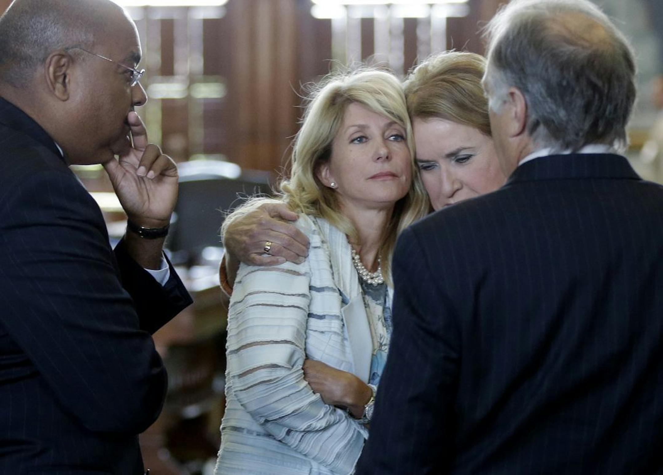 Sen. Wendy Davis, D-Fort Worth, second from left, is hugged by Sen. Sylvia Garcia, D-Houston, as she prepares to filibuster an abortion bill, Tuesday, June 25, 2013, in Austin, Texas. The bill would ban abortion after 20 weeks of pregnancy and force many clinics that perform the procedure to upgrade their facilities and be classified as ambulatory surgical centers. With Davis is Sen. Rodney Ellis, left, and Sen. Kirk Watson, D-Austin, right.