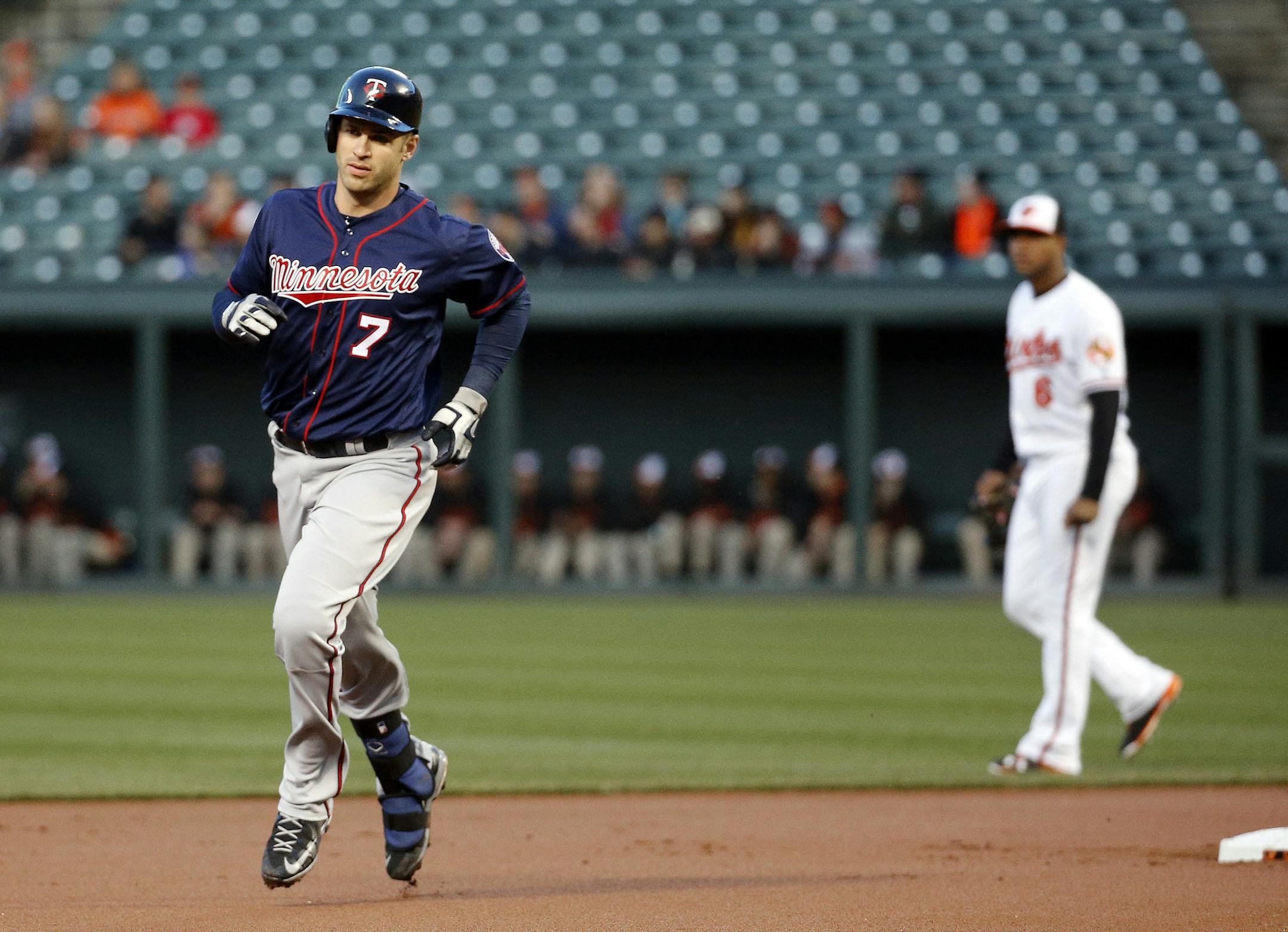 Minnesota Twins' Joe Mauer, left, rounds the bases after hitting a solo home run in the first inning of a baseball game against the Baltimore Orioles in Baltimore, Thursday, April 7, 2016. (AP Photo/Patrick Semansky)