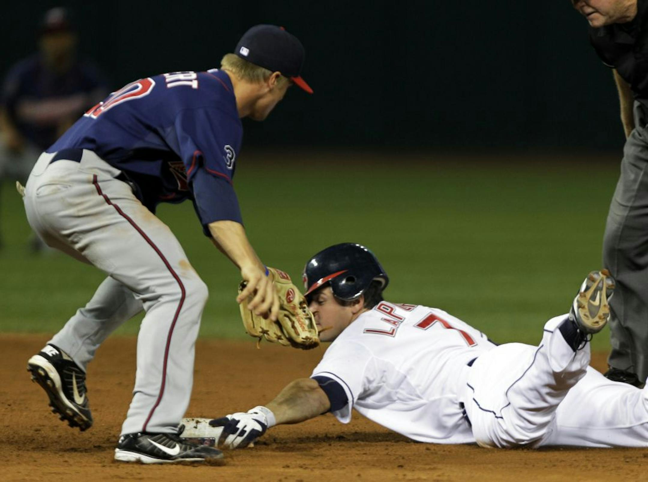 Cleveland Indians' Matt LaPorta, right, slides into second to beat the tag by Minnesota Twins shortstop Matt Tolbert on an RBI double in the eighth inning of a baseball game, Friday, Aug. 12, 2011, in Cleveland. LaPorta drove in Michael Brantley with what proved to be the winning in the Indians 3-2 win over Minnesota.