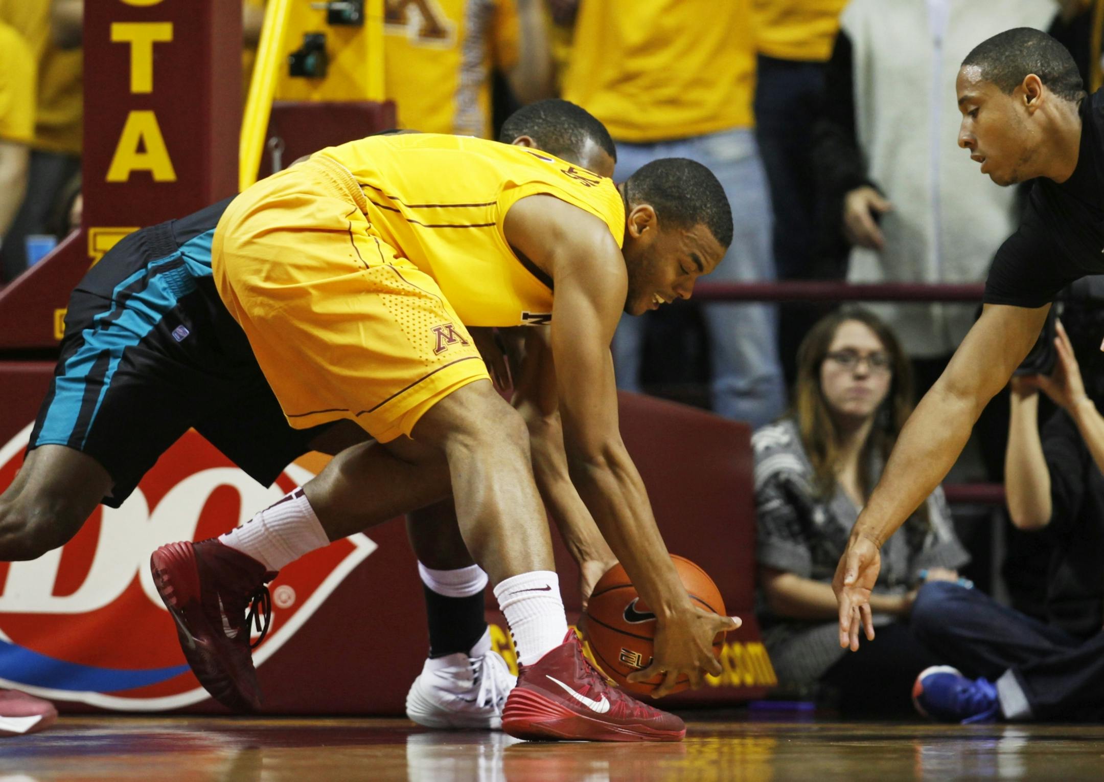 Andre Hollins(1) scrambled for a loose ball against Coastal Carolina.