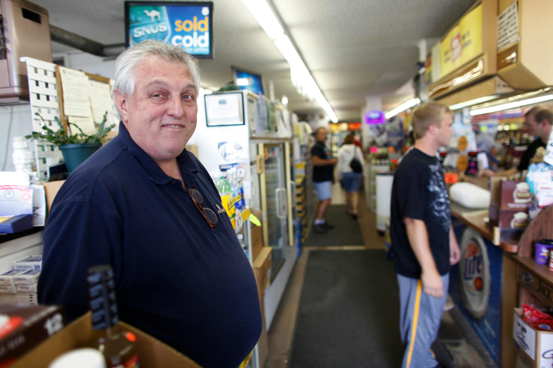 George Cameron stood by as customer purchased liquor at reduced price from his family store.