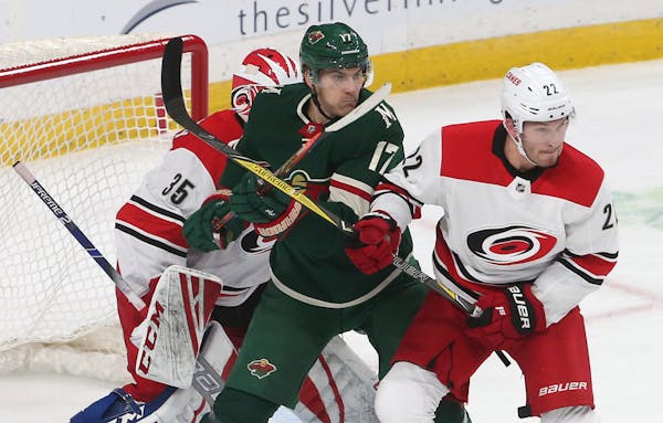 The Wild's Marcus Foligno was bottled up between the Hurricanes' Curtis McElhinney, left, and Brett Pesce during the first period Saturday.