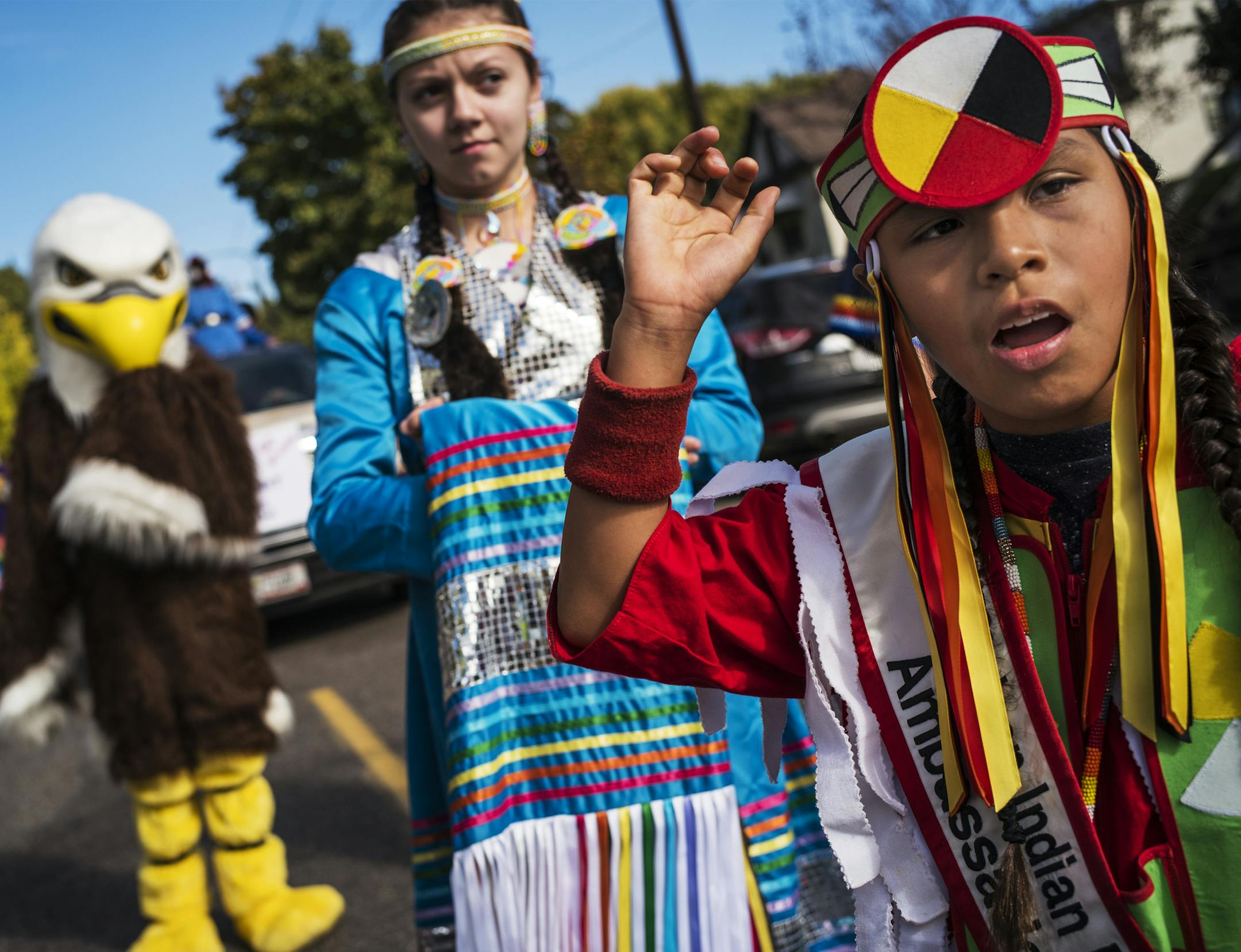 With the school mascot in the background, Styler Kuczaboksi,17, and WakinyanDeCory, 9, are ambassadors who marched with the other children to Mounds Park. Their tribal affiliations are Leech Lake and Red Lake respectively.