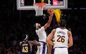 Lakers star Anthony Davis, center, scores during the second half against the Pacers on Sunday in Los Angeles.