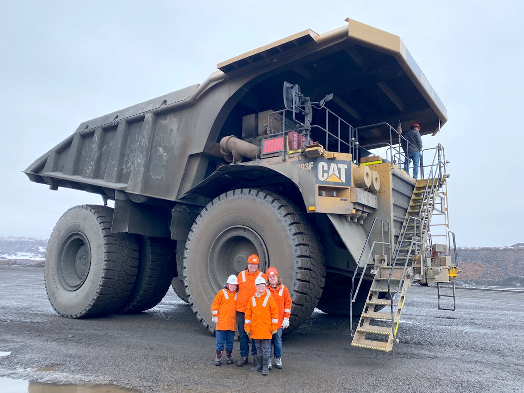 The Munson family in front of the 21-foot-tall Caterpillar dump truck.