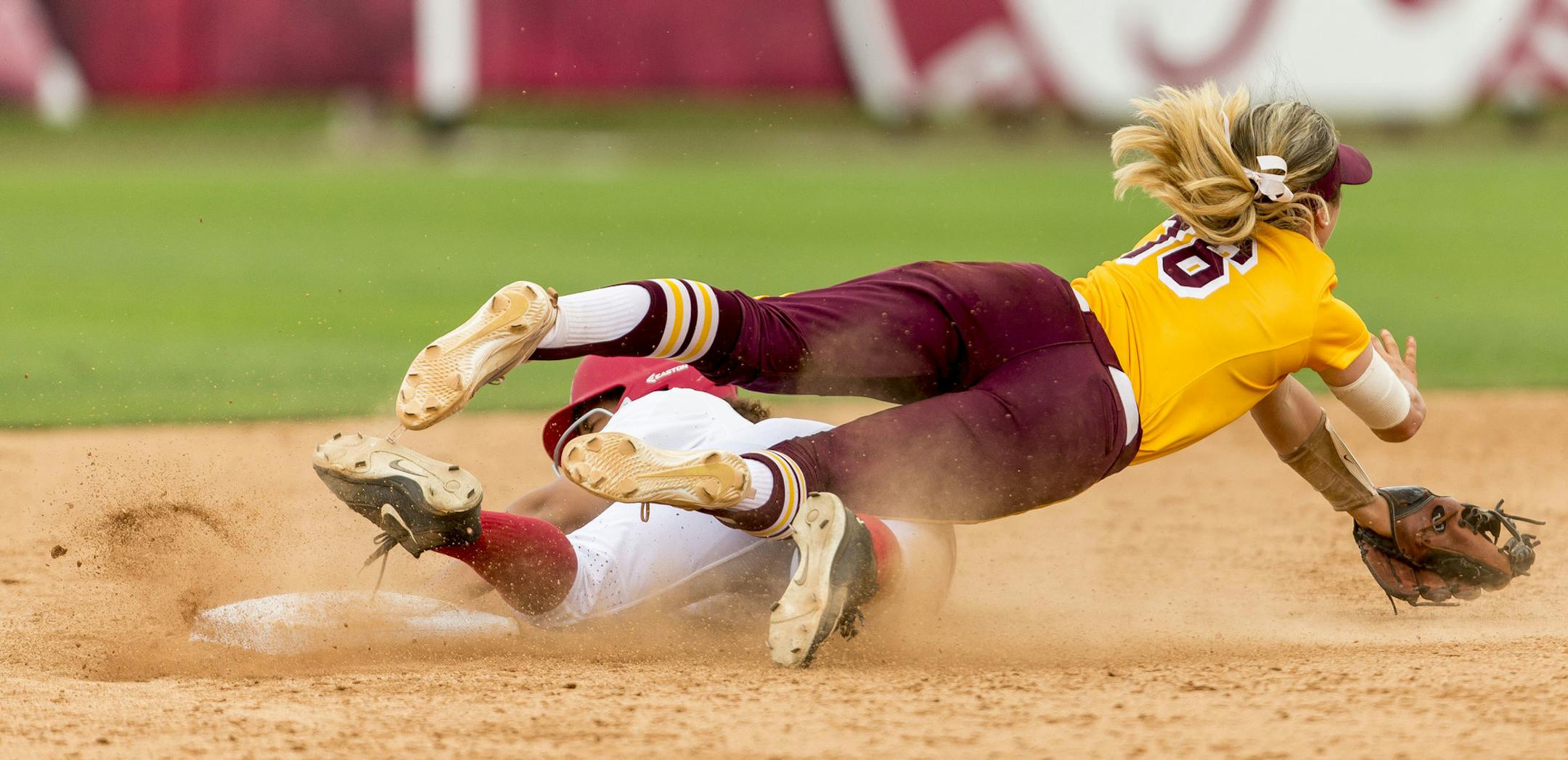 Alabama's Mari Cranek, bottom, slides hard into second, upending Minnesota infielder Allie Arneson (16) in the NCAA regional softball tournament, Saturday, May 20, 2017, at Rhoads Stadium in Tuscaloosa, Ala. Alabama won 1-0. (Vasha Hunt/AL.com via AP)