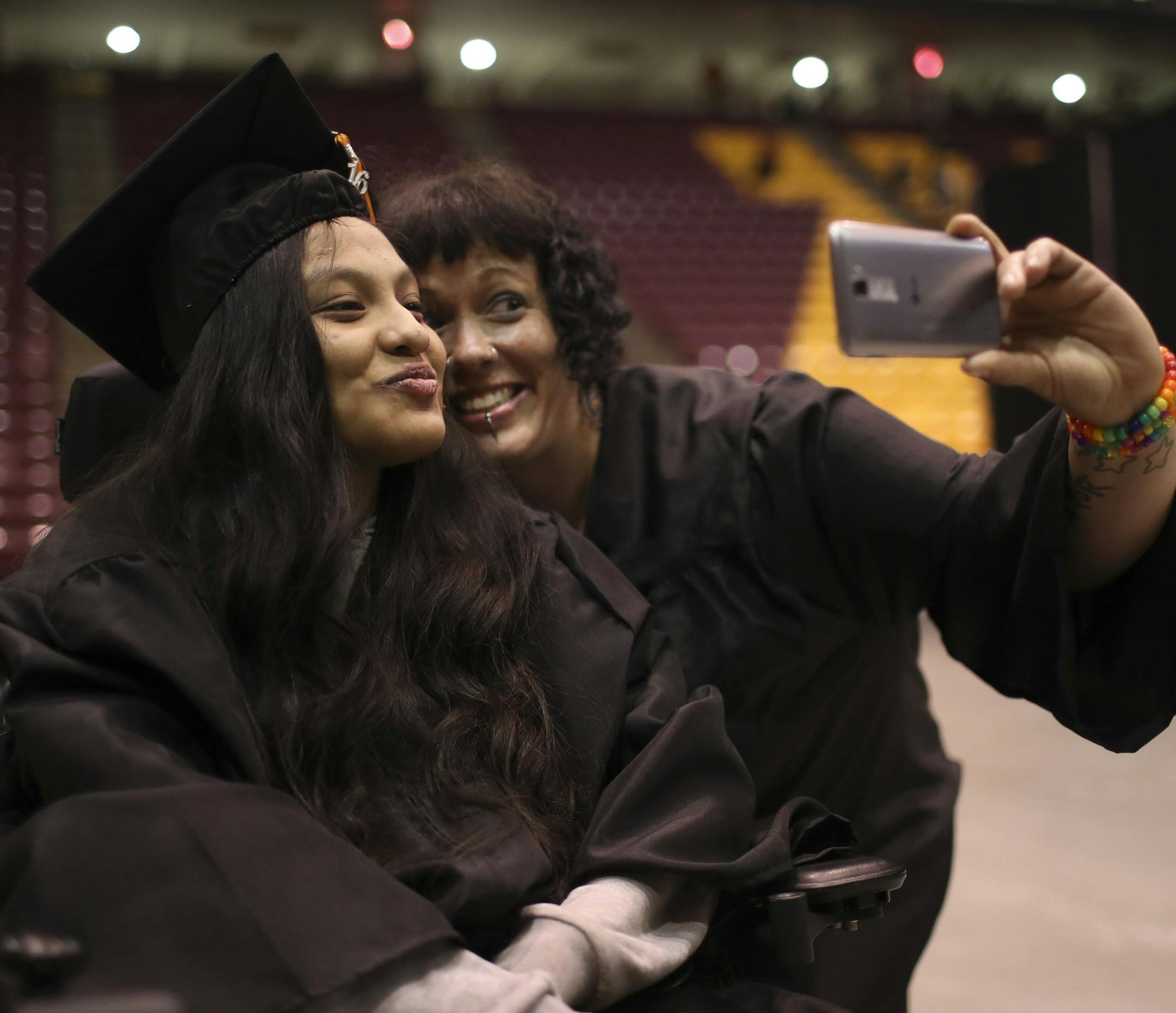 Guadalupe Galeno-Hernandez posed for a selfie with special eduction assistant Talitha Nelson after graduation Tuesday night. ] JEFF WHEELER ï jeff.wheeler@startribune.com Guadalupe Galeno-Hernandez,18, the girl who survived being shot in the throat in November 2010 by a wannabe gangster, graduated from South High School with her class Tuesday night, May 31, 2016 at Mariucci Arena on the University of Minnesota Minneapolis campus.
