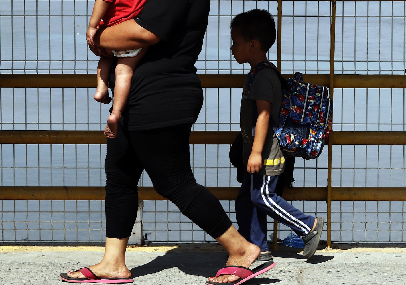 A mother and her two children walk across the Suchiate river bridge as Central American migrants cross the border between Guatemala and Mexico, near Ciudad Hidalgo, Chiapas State, Mexico, Thursday, Jan. 17, 2019. Hundreds of Central American migrants are walking and hitchhiking through the region as part of a new caravan of migrants hoping to reach the United States. (AP Photo/Marco Ugarte)