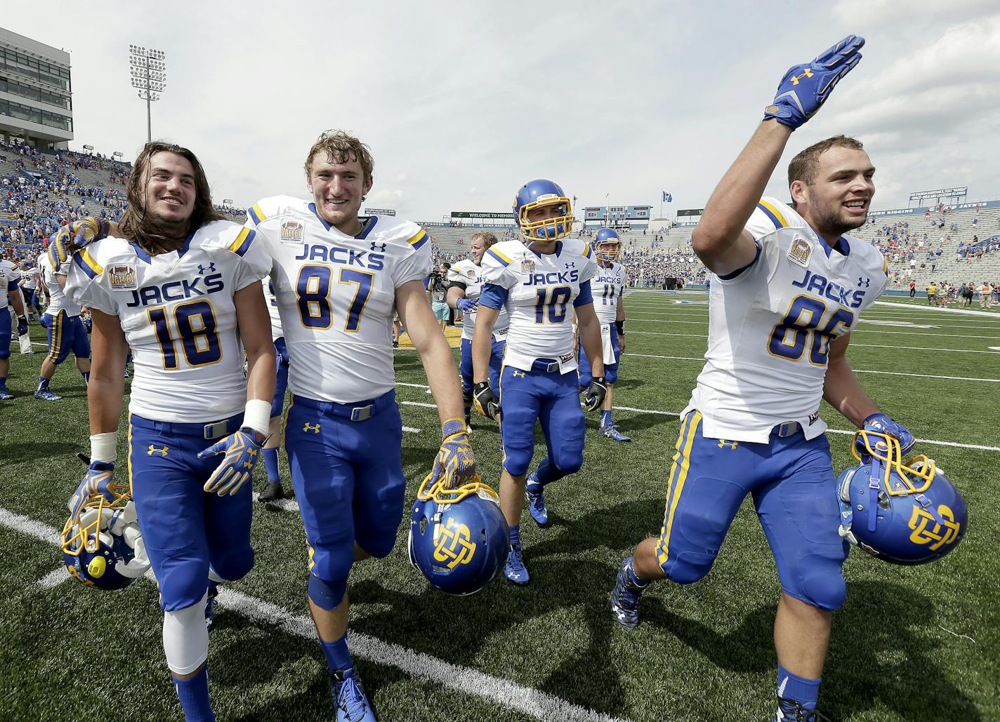 South Dakota State players Connor Landberg (18), Mitch Vejvoda (87), Alex Wilde (10) and Dallas Goedert (86) celebrate after their NCAA college football game against Kansas Saturday, Sept. 5, 2015, in Lawrence, Kan. South Dakota State won 41-38. (AP Photo/Charlie Riedel)