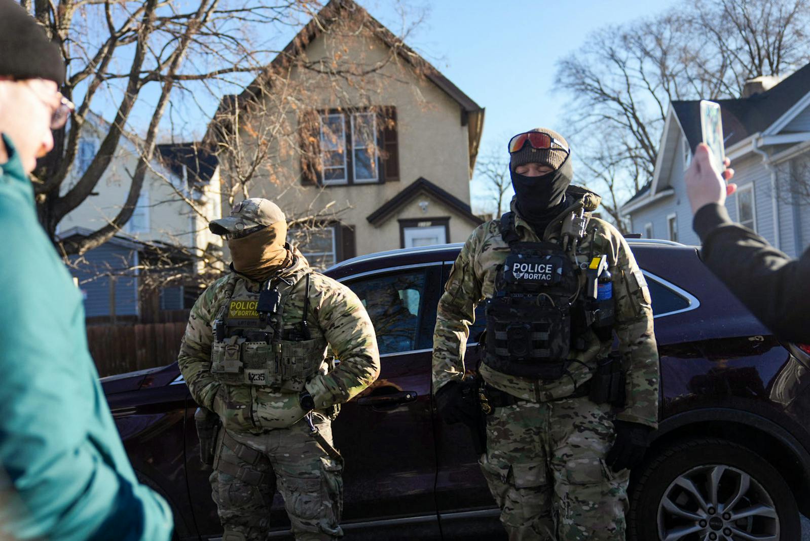ICE agents stand near their cars near 31st Avenue N & N 3rd Street on Jan. 14 in Minneapolis. 