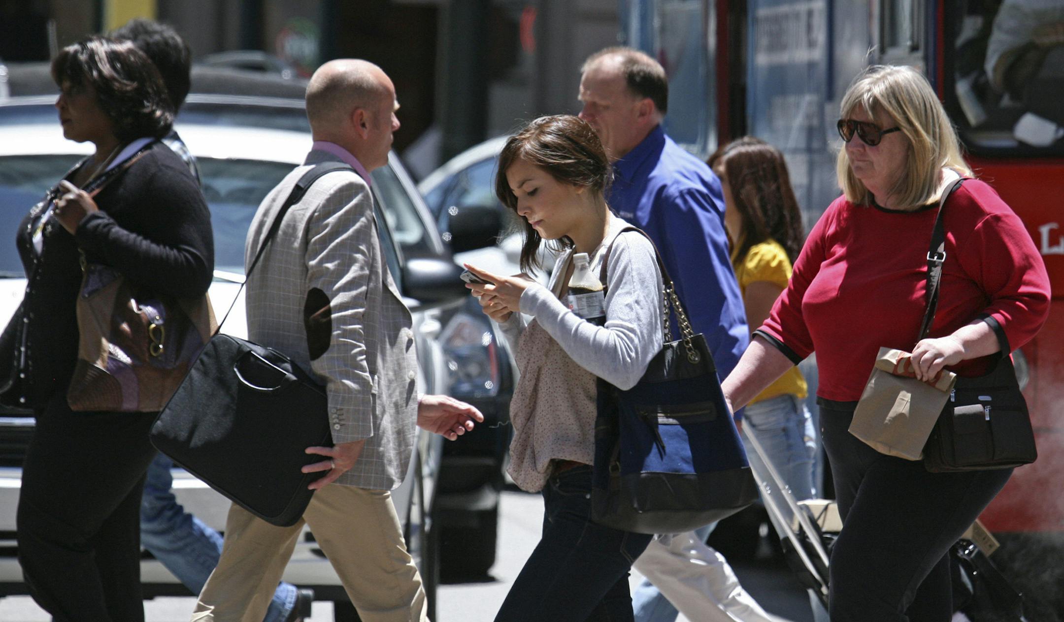 In this photo taken Wednesday, June, 29, 2010, a woman text messages while walking across the street in San Francisco. While using a cell phone while driving has triggered the most alarm bells and prompted laws in several states, experts say pedestrians are also suffering the consequences of mobile distraction tripping on curbs, walking into traffic, even stepping into manholes as they chat or type while walking. (AP Photo/Ben Margot) ORG XMIT: MIN2015031314214929