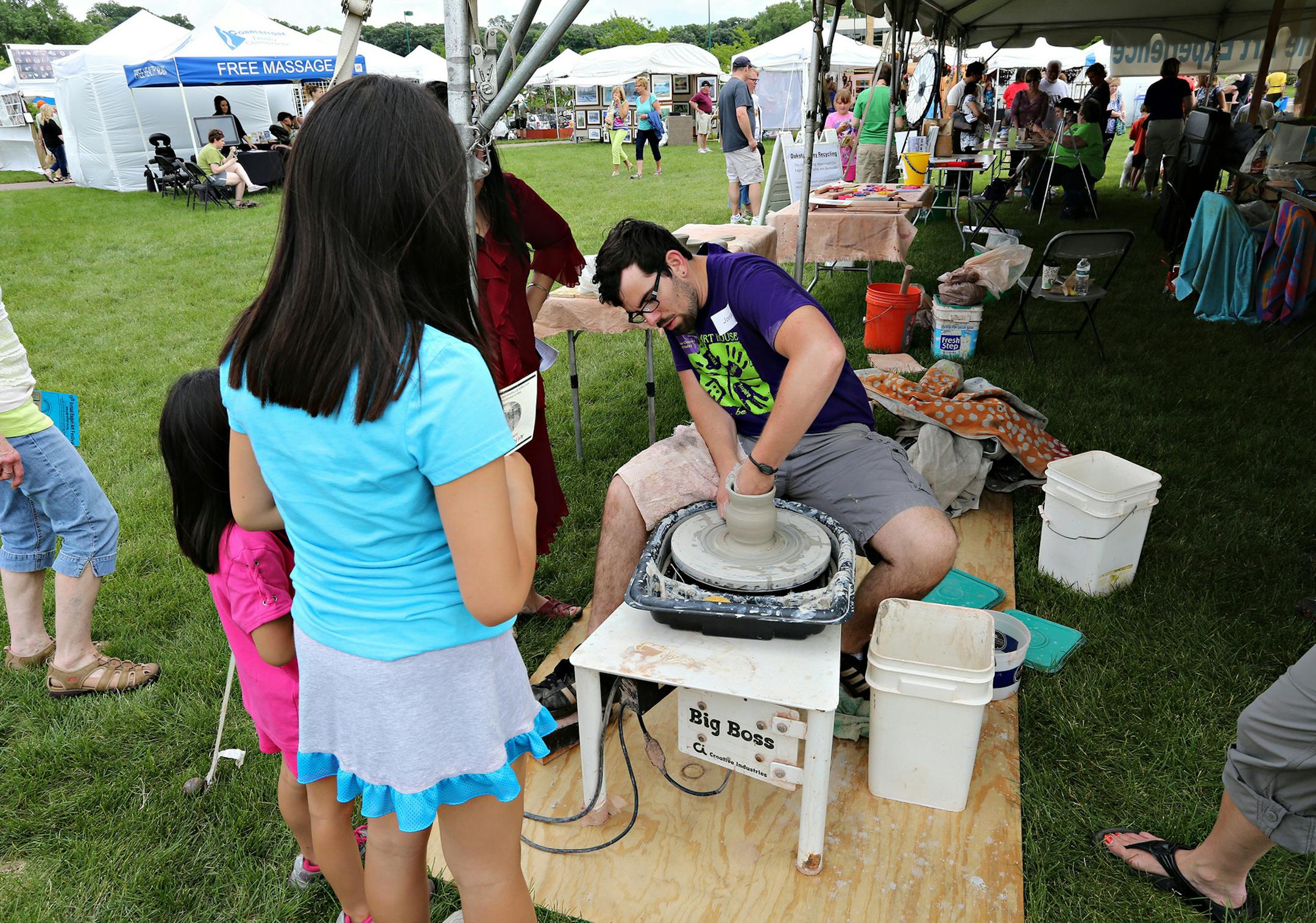 Eagan Art House staff member Jordan Landauer demonstrated how to use the wheel at the 2013 Eagan Art Festival. (Photo by Fred Miller)