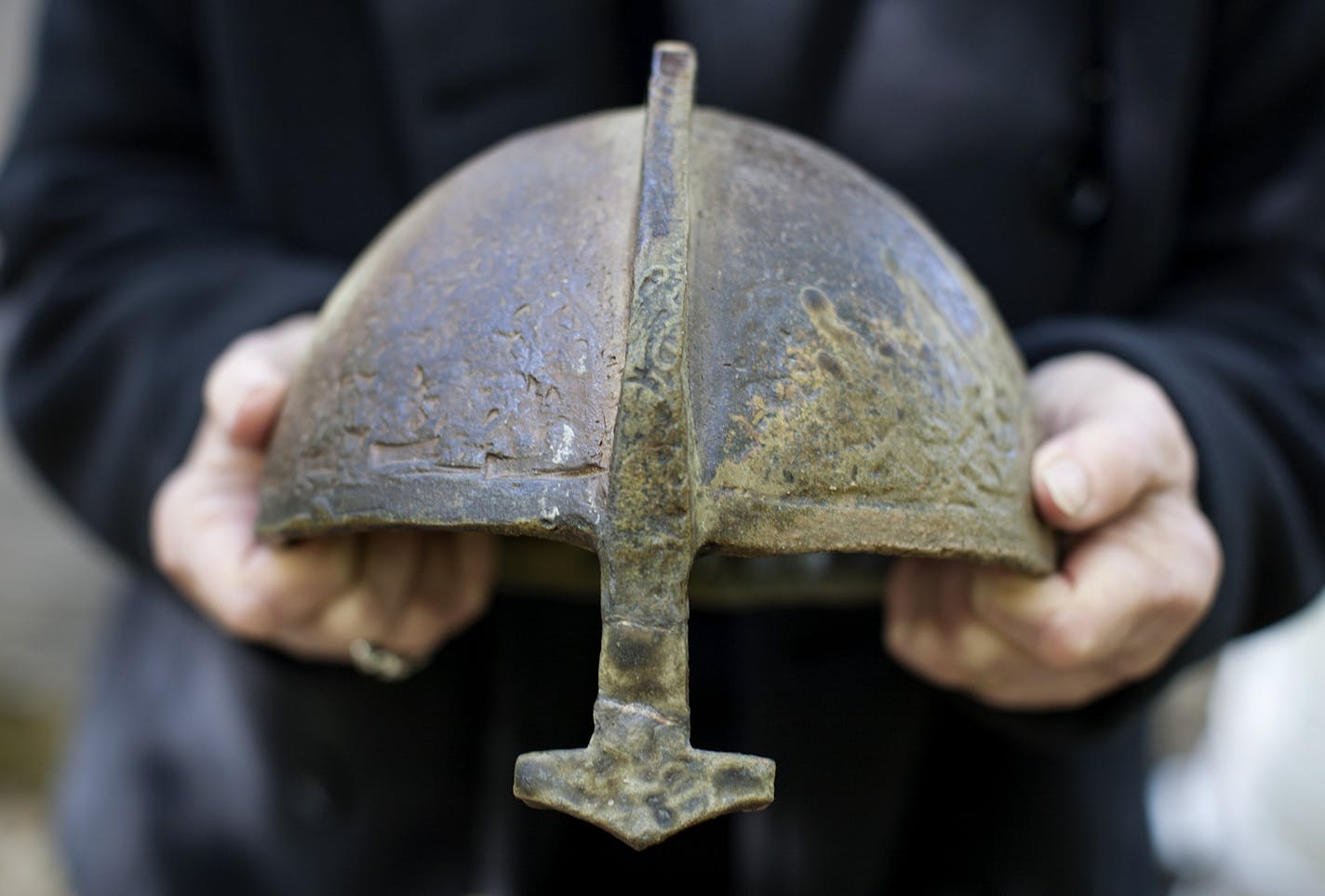 Artist Nancy Randall holds a helmet she created at her home in Hopkins October 10, 2014. Randall's upcoming retrospective at Saint John's University in Collegeville will feature many similar works laid and partially buried outdoors in a woodland setting. (Courtney Perry/Special to the Star Tribune)