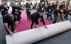 Crew members are trailed by media as they roll out the red carpet for Sunday's 90th Academy Awards in front of the Dolby Theatre on Wednesday, Feb. 28