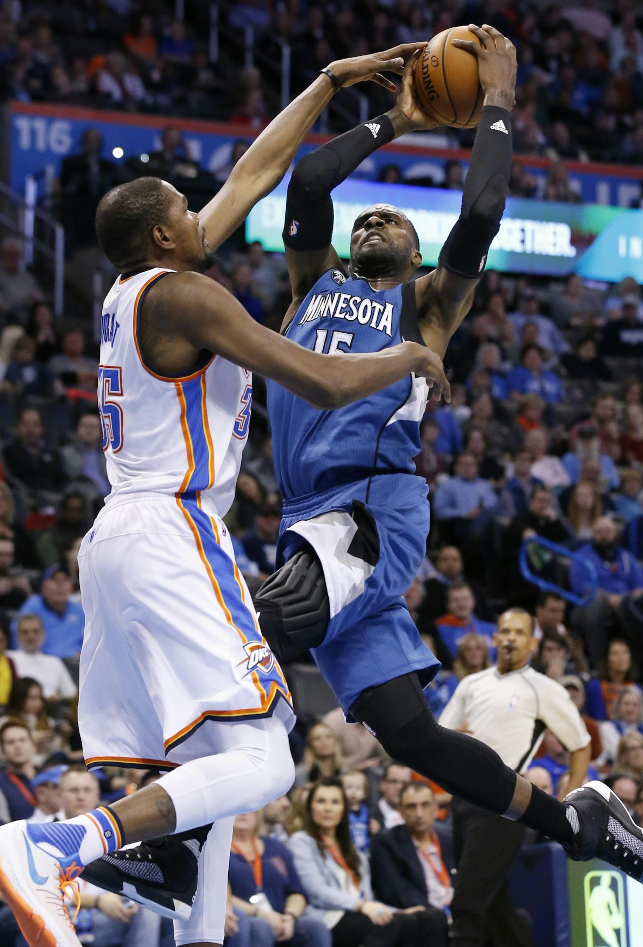 Minnesota Timberwolves forward Shabazz Muhammad, right, goes up for a shot as Oklahoma City Thunder forward Kevin Durant defends during the second quarter of an NBA basketball game in Oklahoma City, Friday, Jan. 15, 2016. (AP Photo/Sue Ogrocki)