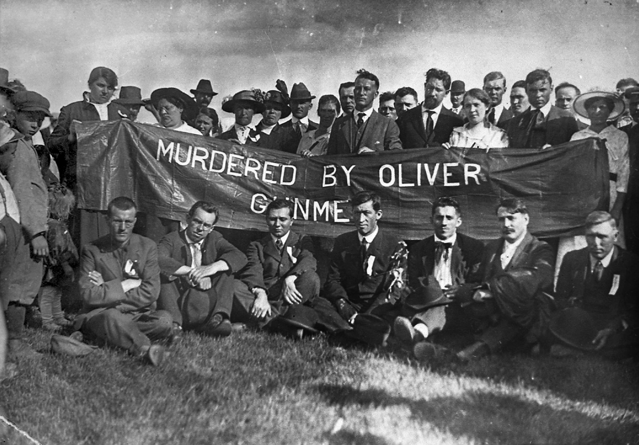 Striking workers and family members pose with the sign they carried during the funeral march for Croatian miner John Alar in Virginia, Minn.