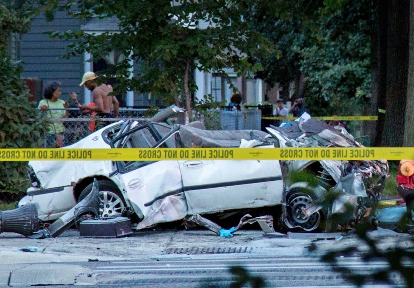 A totaled car sits on the sidewalk after it collided with a bus during a fatal crash in St. Paul on July 21, 2017.