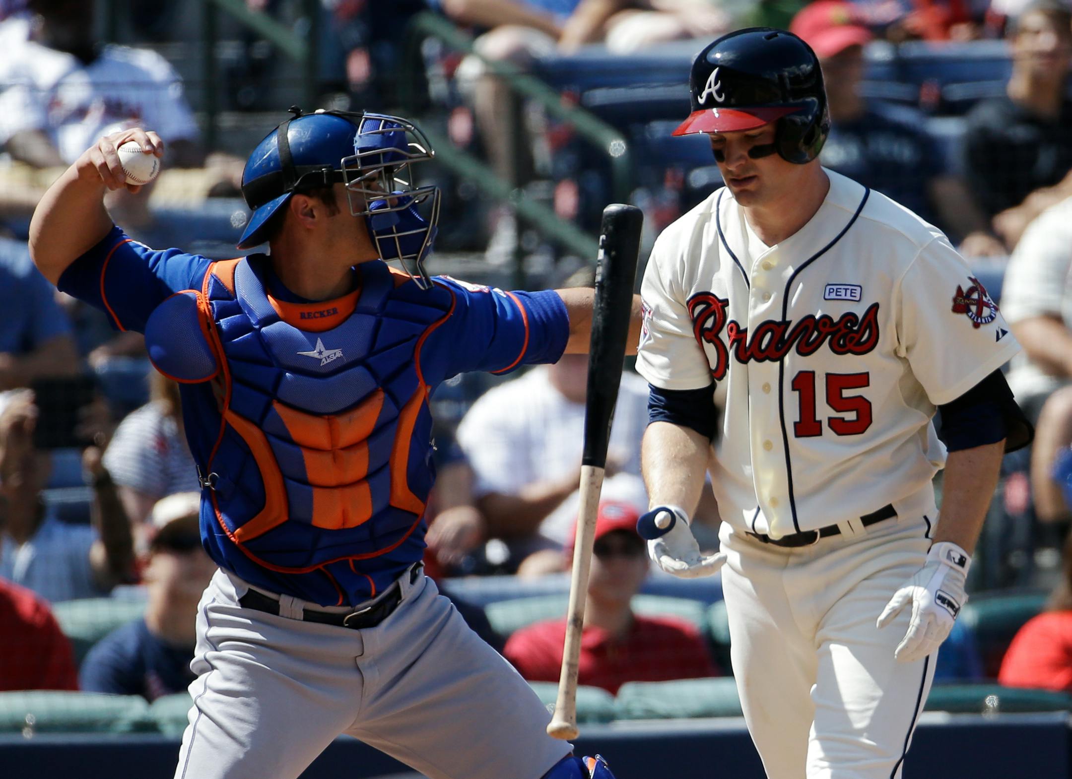 Atlanta Braves' Phil Gosselin, right, flips his bat as he strikes out while New York Mets catcher Anthony Recker, left, throws the ball to the infield in the fifth inning of a baseball game, Sunday, Sept. 21, 2014, in Atlanta. (AP Photo/David Goldman)
