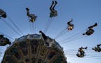 Fair goers on the swings at the "Kidway" from below at a kids height at the Minnesota State Fair in Falcon Heights, Minn., on Thursday, August 22, 201