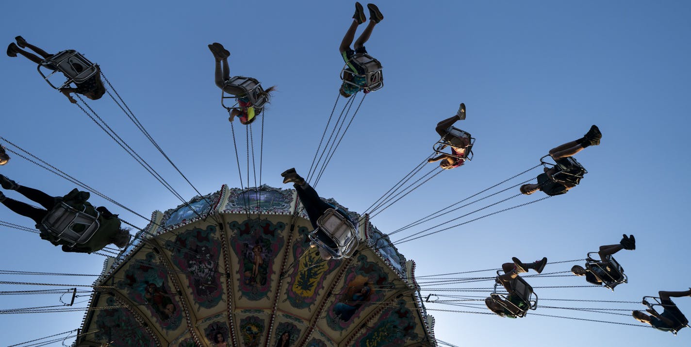 Fair goers on the swings at the "Kidway" from below at a kids height at the Minnesota State Fair in Falcon Heights, Minn., on Thursday, August 22, 2019. ] RENEE JONES SCHNEIDER ¥ renee.jones@startribune.com Kids perspective of the fair