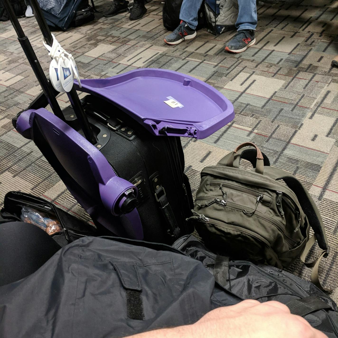 Stolen stadium seat after getting through airport security, waiting to be carried on plane.