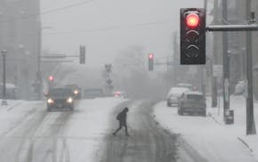 A pedestrian crosses the street on West Franklin Avenue near Lyndale Friday, Dec. 10, 2021 in Minneapolis, Minn. The Twin Cities saw the first signifi