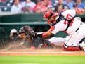 Twins center fielder Byron Buxton is tagged out by Nationals catcher Keibert Ruiz as he attempted to score from first on a double by Willi Castro duri