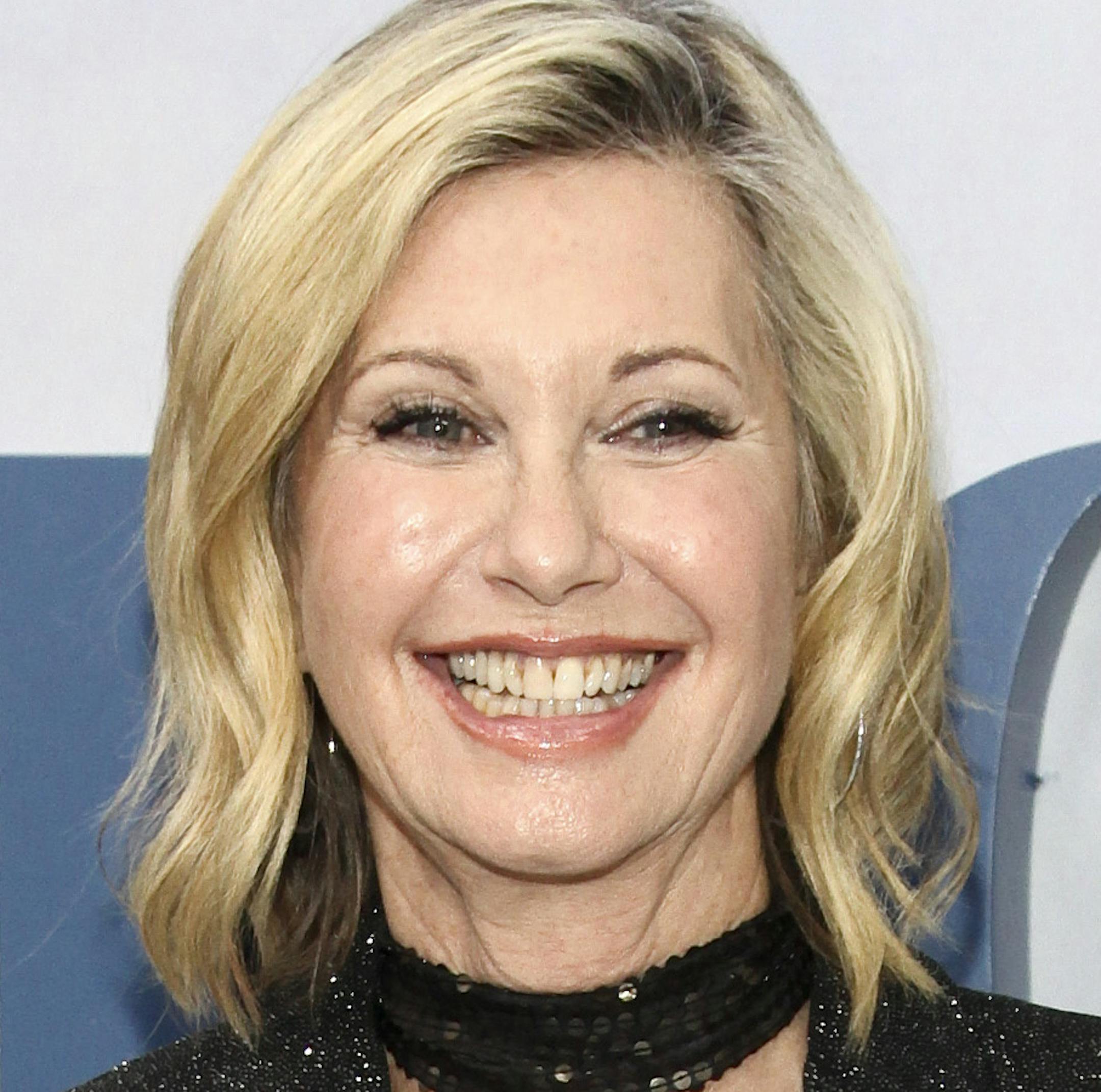 FILE - In this Oct. 4, 2016 file photo, actress and singer Olivia Newton-John attends the premiere of HBO's "Divorce" in New York. Newton-John says she has breast cancer and is canceling her June tour. The 68-year-old singer announced Tuesday, May 30, 2017, that she initially thought she was suffering from back pain, but learned it was “breast cancer that has metastasized to the sacrum.” (Photo by Andy Kropa/Invision/AP, File)