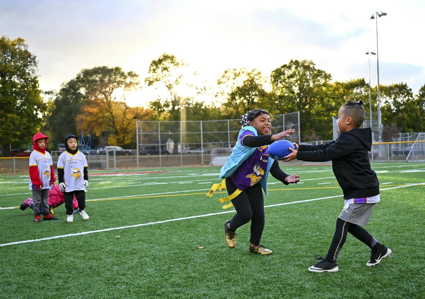 Chinyu Jordan Her, 6 handed off the ball to Catalia Farmer, 8 during flag football practice Wednesday night. ] AARON LAVINSKY • aaron.lavinsky@startribune.com A story looking at how COVID-19 continues to impact youth sports. Between volunteer coaches having to add COVID protocols to their duties in some cities to others moving away from traditional soccer and football games to more of a skills camp setting, the virus didn't completely derail kids sports. But it sure changed what the kids, parent