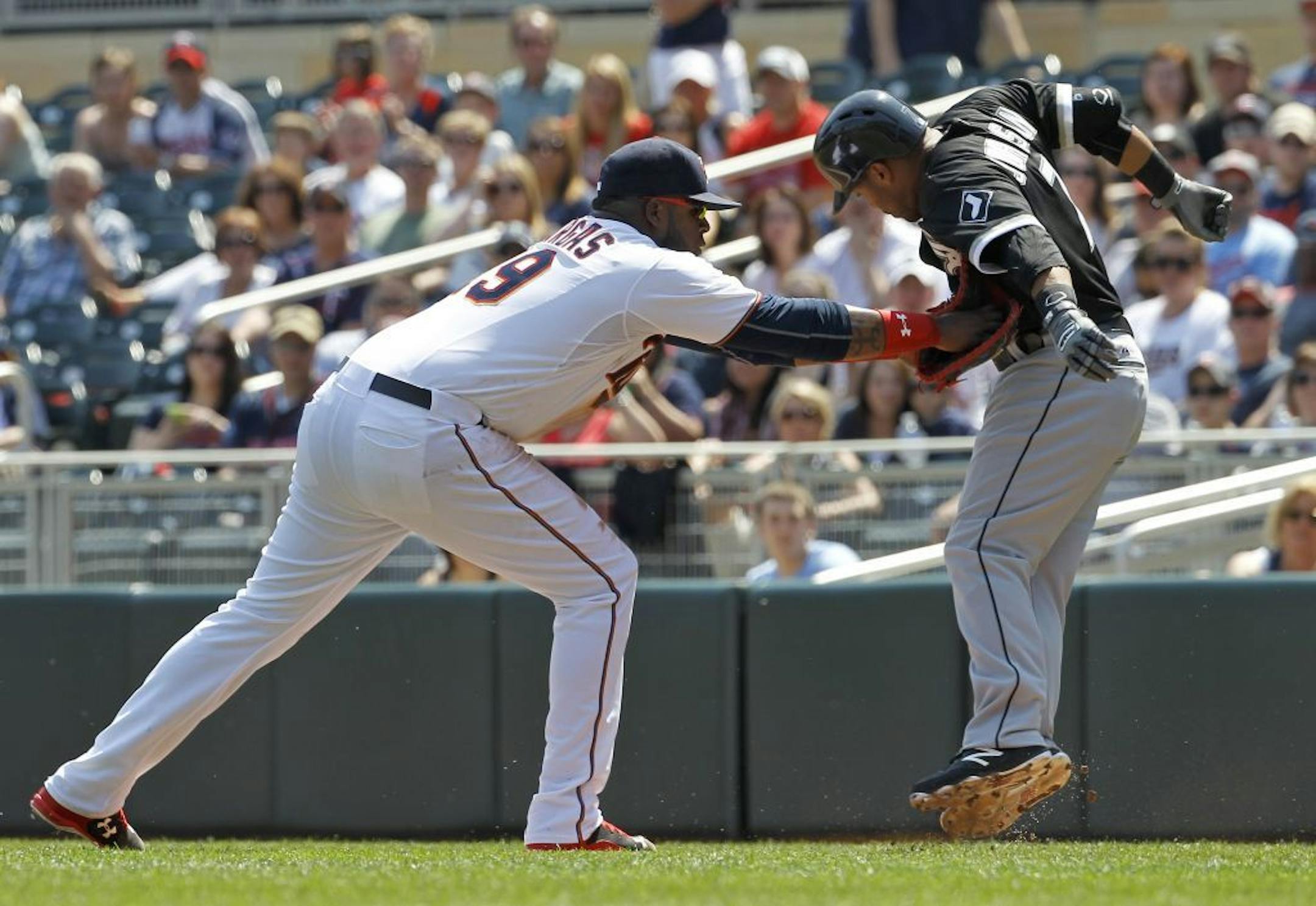Chicago White Sox's Micah Johnson, right, runs into the tag by Minnesota Twins first baseman Kennys Vargas, left, on a sacrifice to first during the third inning a baseball game in Minneapolis, Sunday, May 3, 2015.