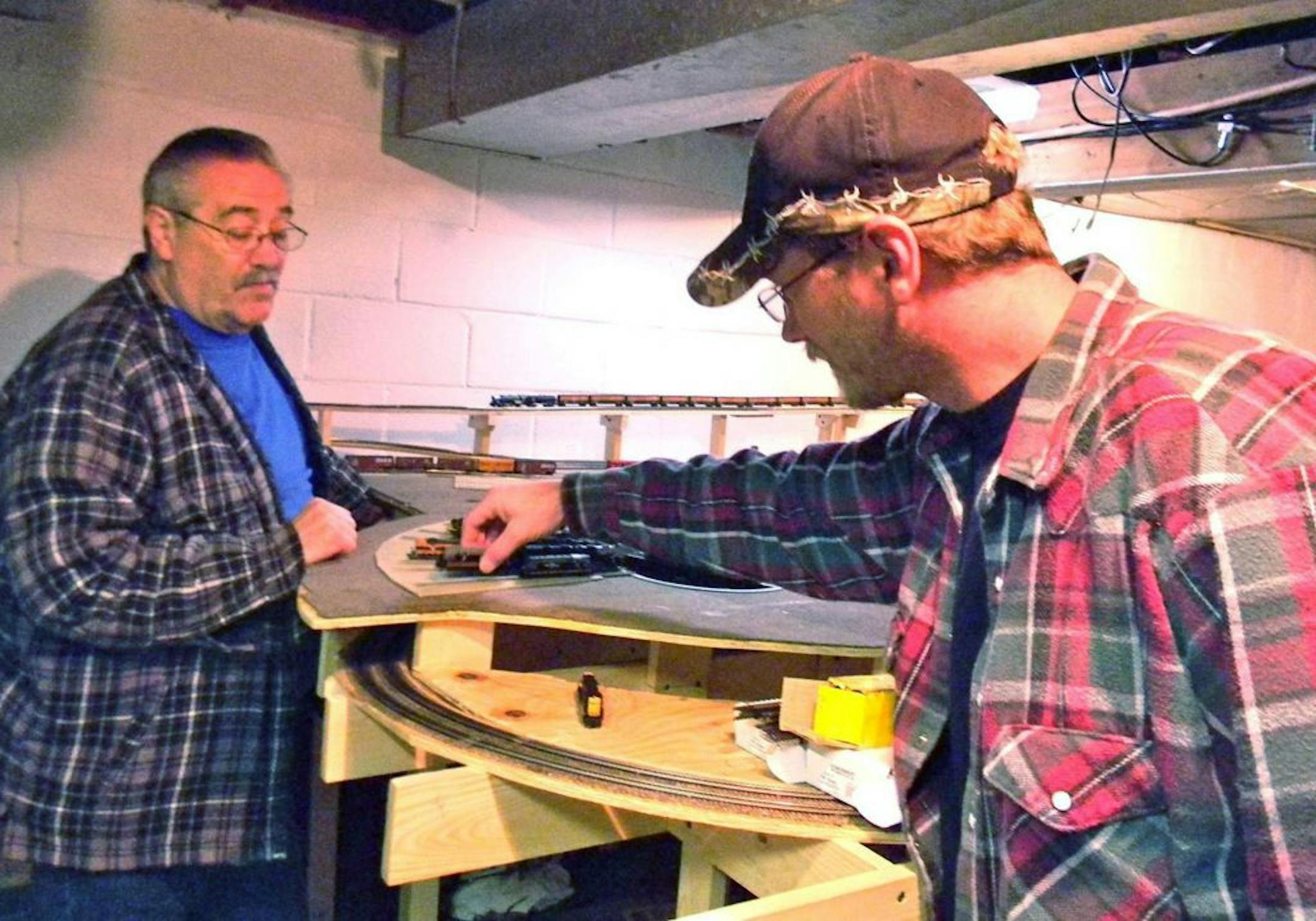 Troy Pendzimas, right, started on an N-scale model railroad set about three years ago for his daughter. The project soon required help from his father, George, left, a former railroad engineer.