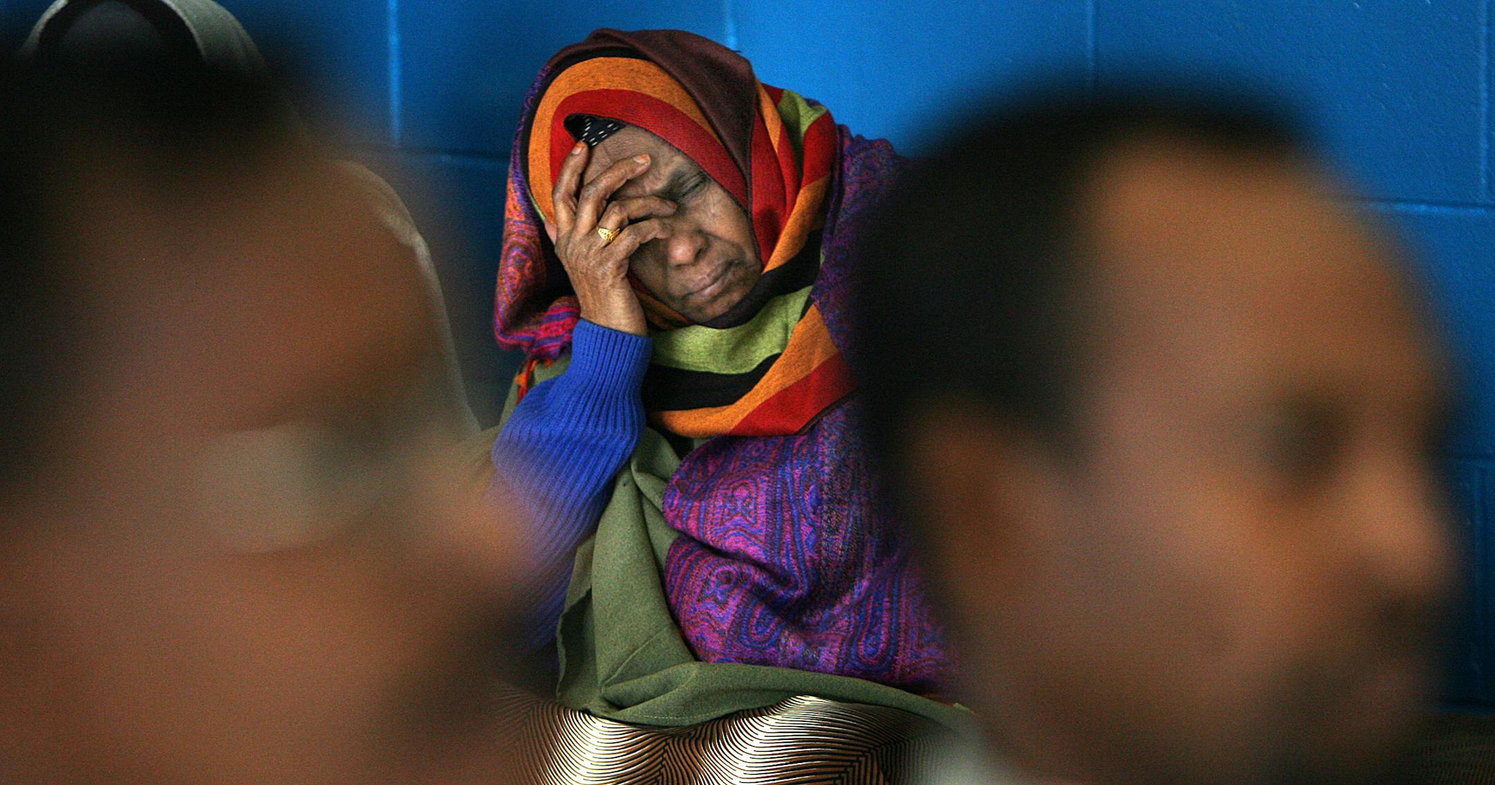 A woman listened as Abdirizak Bihi, left, and Osman Ahmed spoke at a Minneapolis news conference Saturday about three young men from Somali families in Minnesota, who have apparently disappeared.