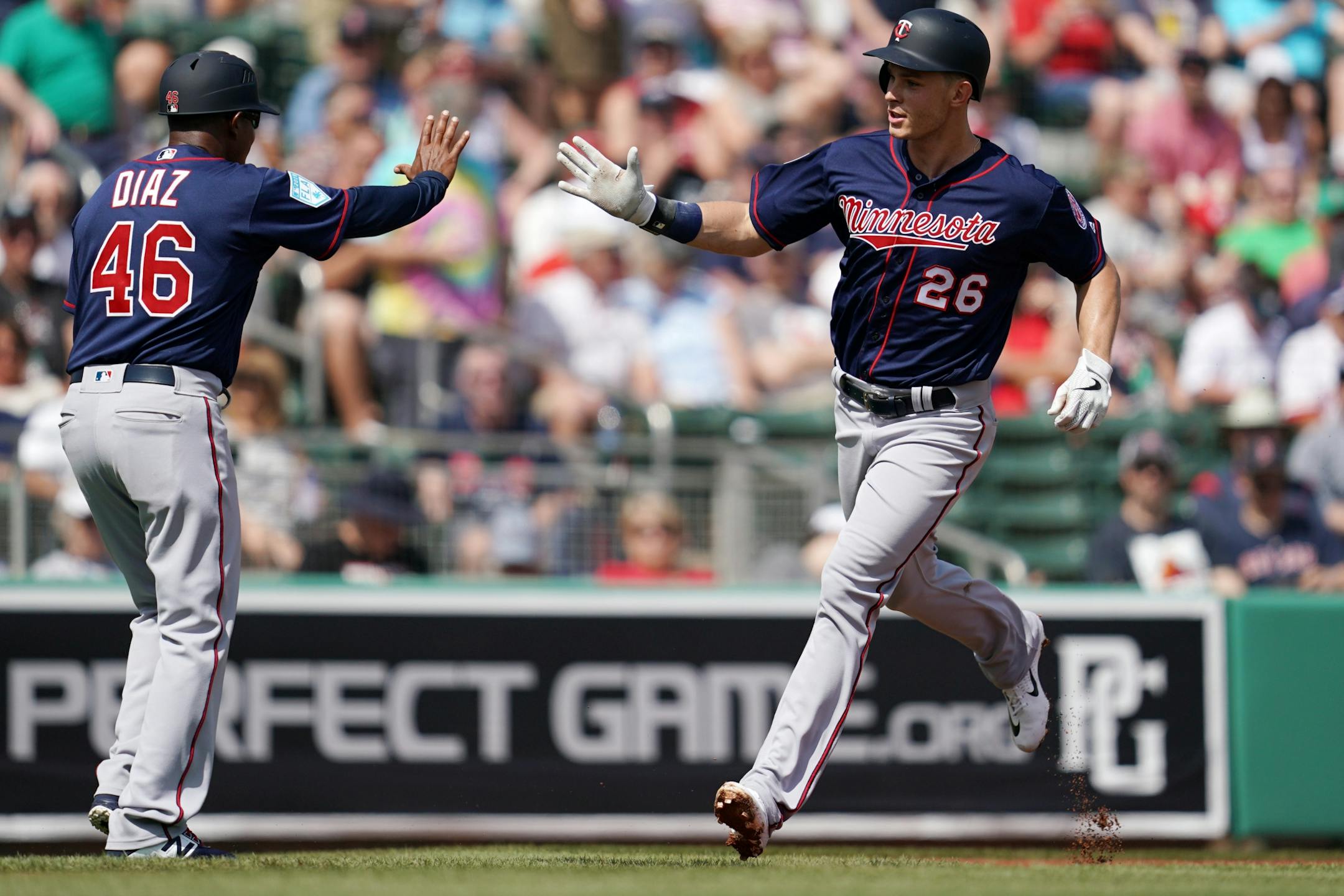 Minnesota Twins right fielder Max Kepler (26) was congratulated by Minnesota Twins third base coach Tony Diaz (46) as he rounded third after hitting a home run in his first at bat during Sunday's game.